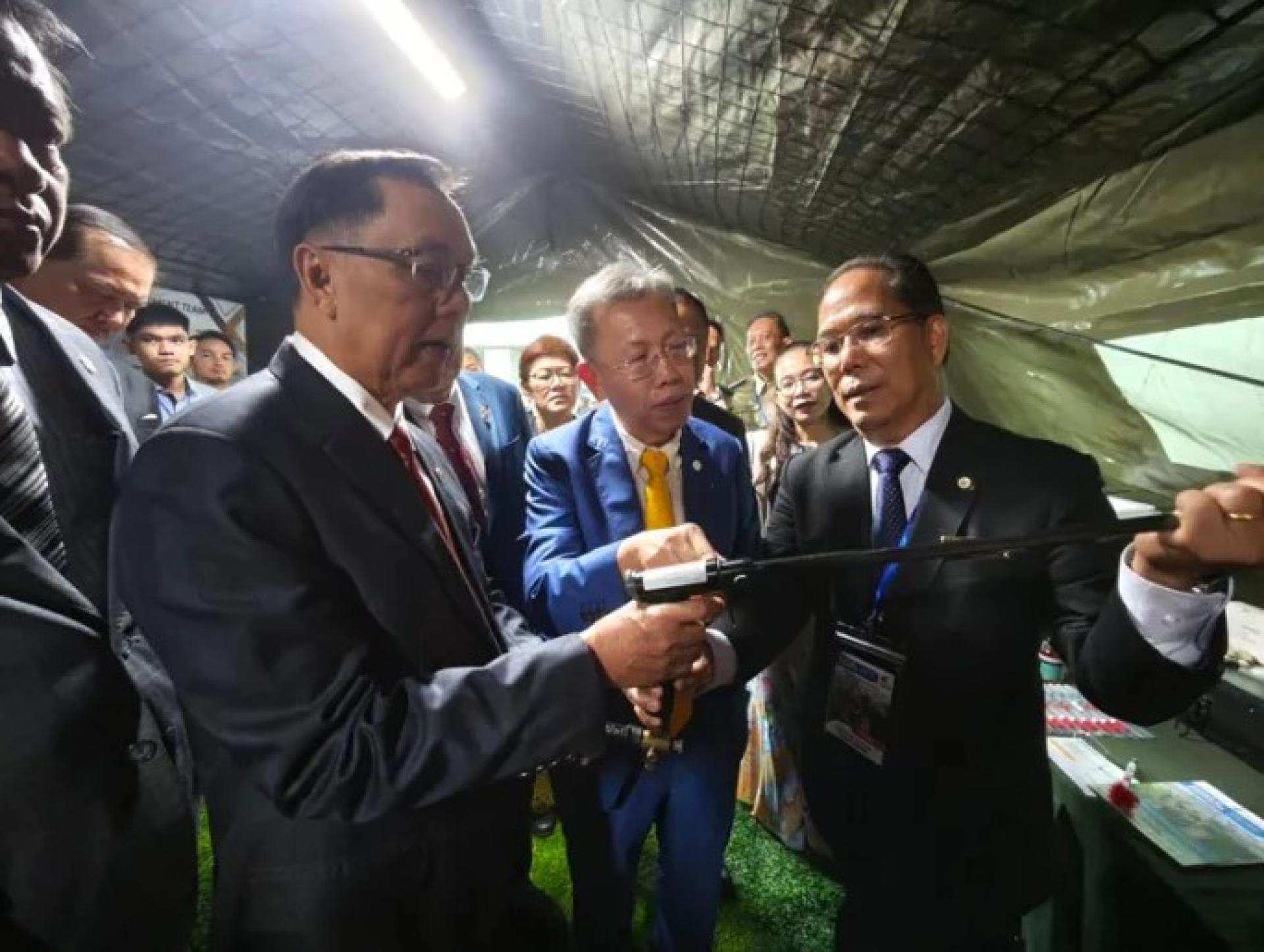 史蒂芬伦迪医生（左）与沈桂贤医生（中）、砂兽医局局长拿督安德廉医生，一同在BCCK参观RIB 2025展区时，查看麻醉枪（2025年9月30日）。