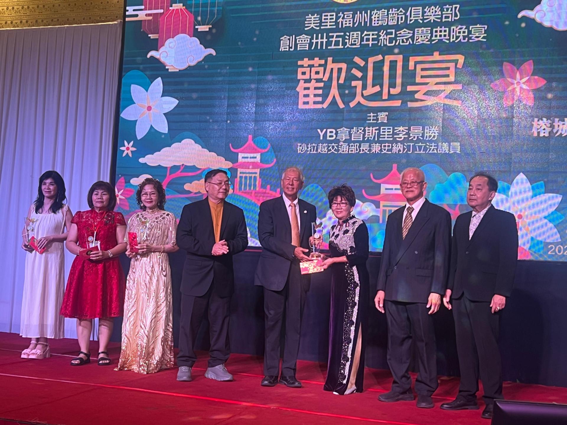 砂拉越旅游部副部长拿督陈超耀（左5）颁发属会理事组委男女华语歌唱比赛女子组冠军给来自美里屏南公会的徐小菁。右起为砂拉越福州乐龄（鹤龄）总会会长林唐锦及美里福州鹤龄俱乐部主席俞贤崧。
