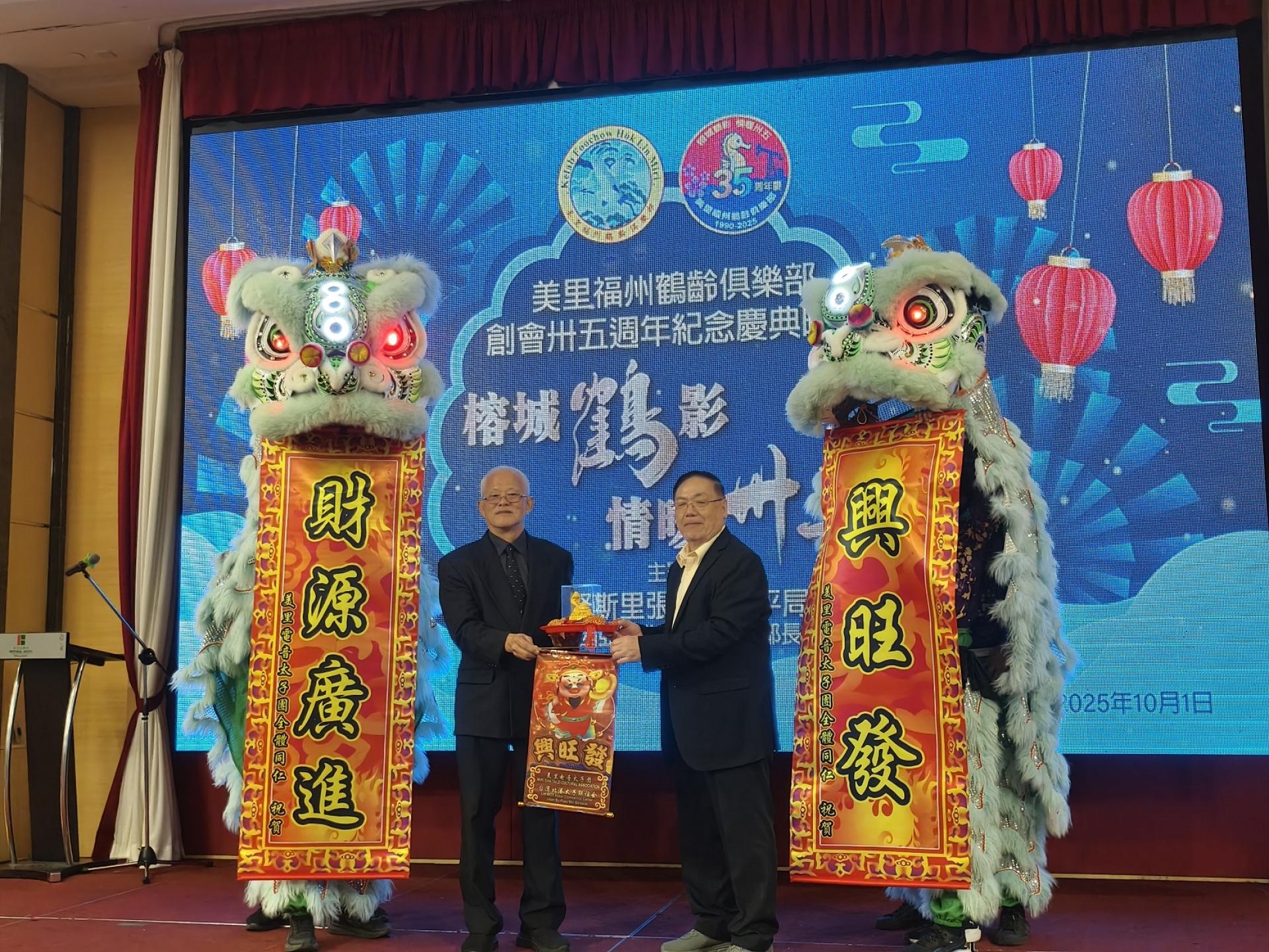 美里福州鹤龄俱乐部35周年纪念庆典晚宴舞狮表演后，大会主席俞贤崧（左）和筹备会主席黄其昌（右）在接青，也代表着接到了福运财运。