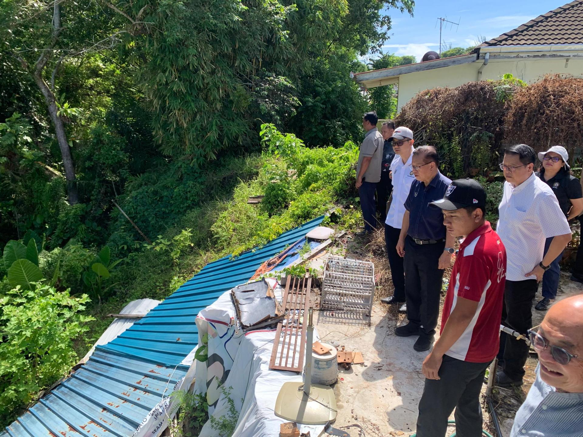 美里翡翠山庄2号路住宅区后巷发生坍塌多时至今未获得处理，李景胜（中）巡视现场。