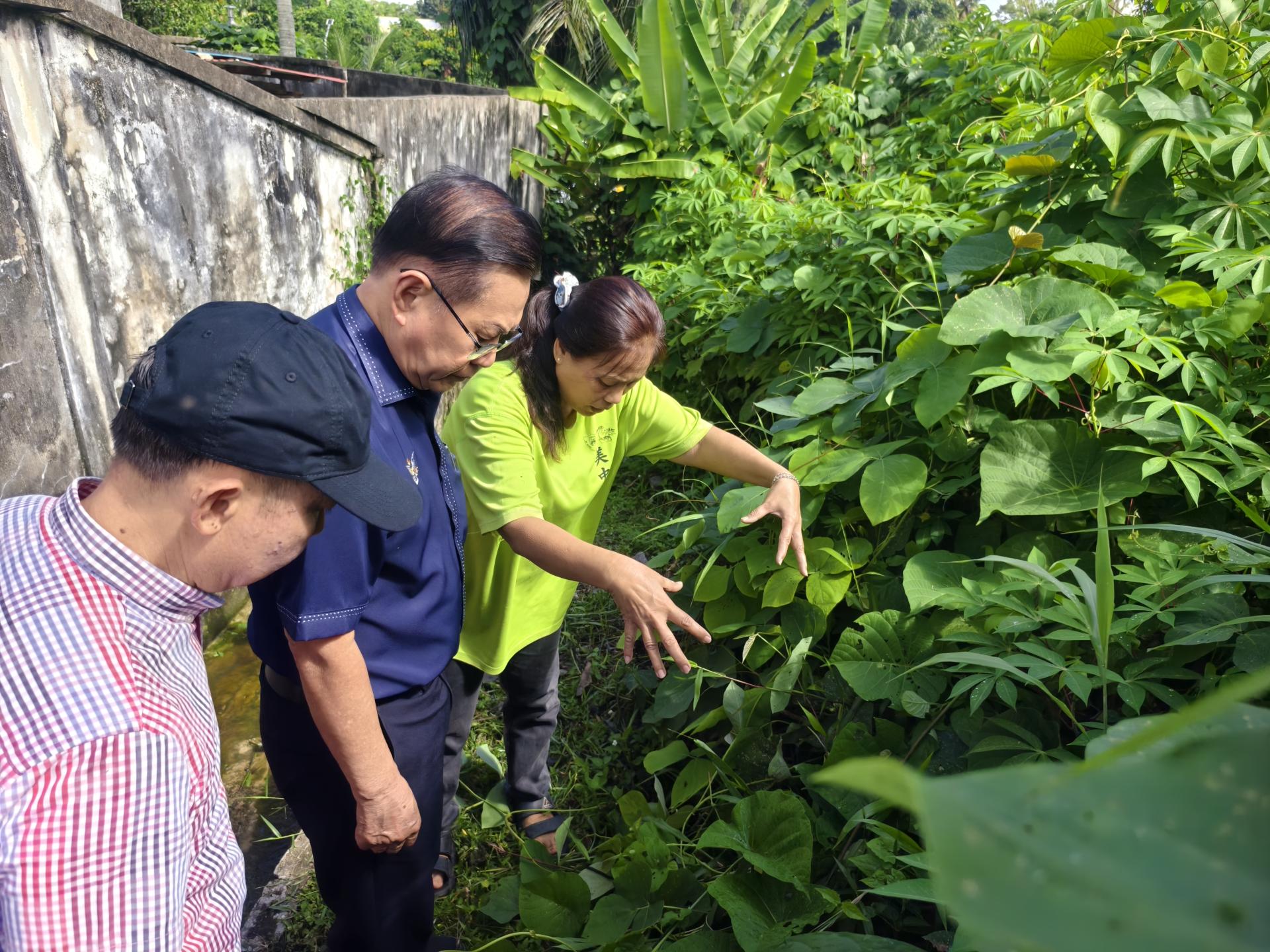居民（右）向前到巡视的砂交通部长拿督斯里李景胜说明住宅区排水沟坍塌与渗水问题。