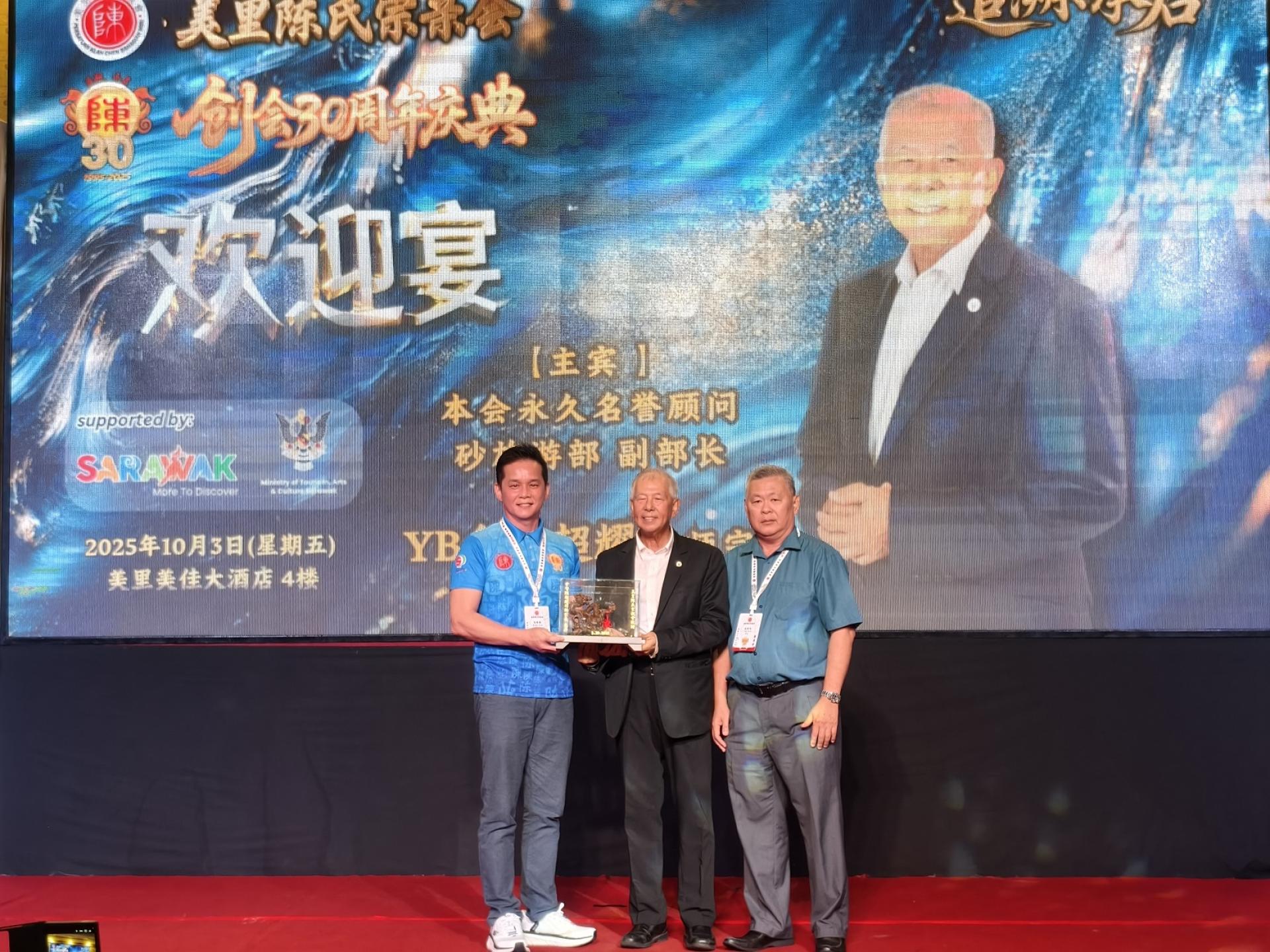 筹委会主席陈德毅（左）赠送纪念品给主宾砂旅游部副部长兼美里陈氏宗亲会永久名誉顾问拿督陈超耀。右为大会主席兼会长陈绍和。