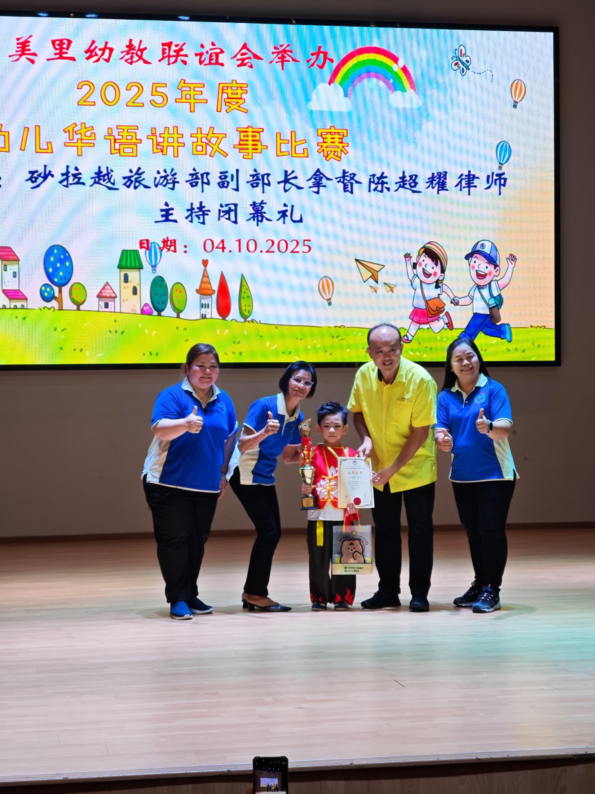 “2025年幼儿华语讲故事比赛”主宾拿督超耀的代表美里市议员陈立仁（右2）颁发冠军给来自大埔幼稚园的叶韦毅。右为美里幼教联谊会主席沈秀芳园长、左为副主席吴妙云园长及筹备会主席陈葆花园长（左2）。