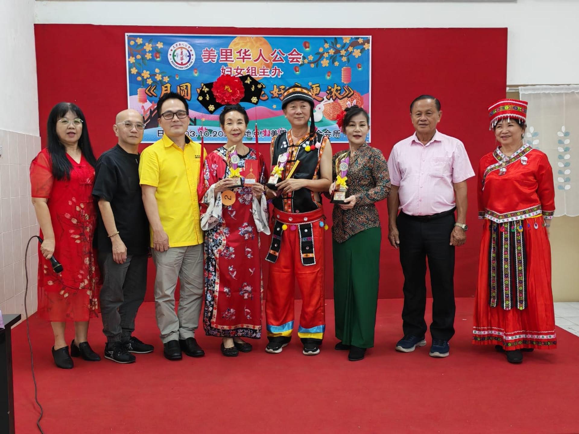 美里华人公会妇女组中秋晚会民族服装赛得奖者与嘉宾合影。左起为妇女组主任詹有珊、会长张昌盛、美里市长俞小珊的代表张嵻洺、季军吴宝贤、亚军林友义、冠军黄赛华、署理会长兼妇女组顾顧问甲必丹严学忠，以及筹备会主席郑翠妃。