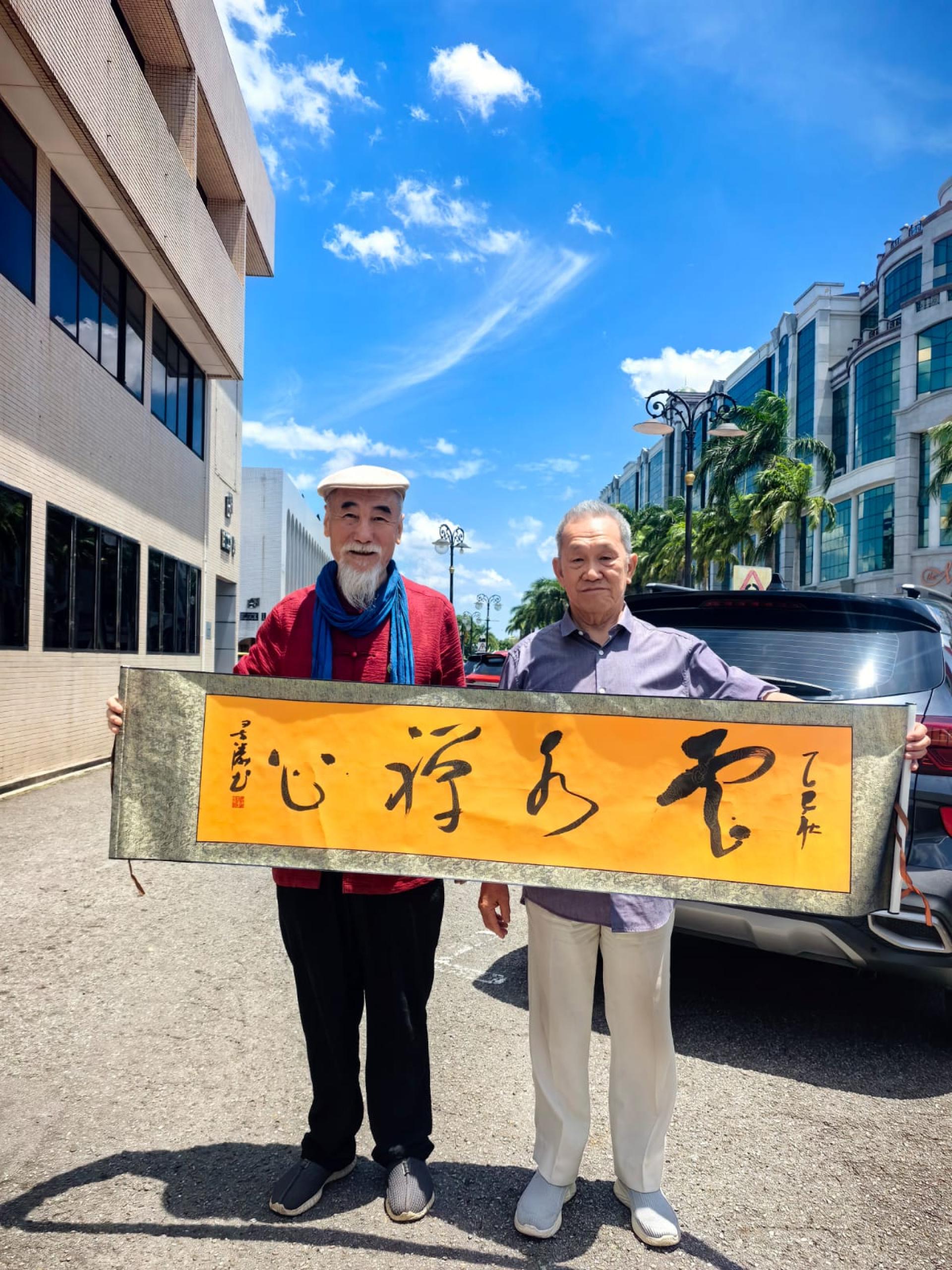 张井涛（左）赠送墨宝给孙德安。