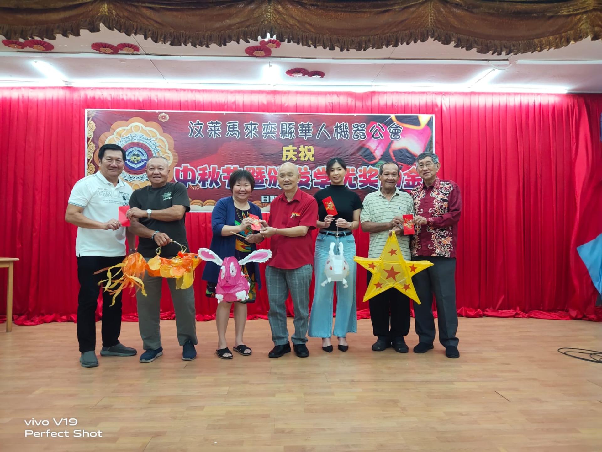 永久名誉会长刘小源，会长陈观成，第一副会长刘芝新颁发红仪给制作灯龙等奖者