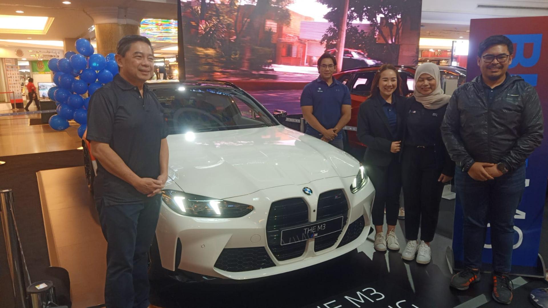 首 署部长兼第二财政与经济部长拿督刘光明参观轿车后与QAF Auto职八在宝马轿车前合影
