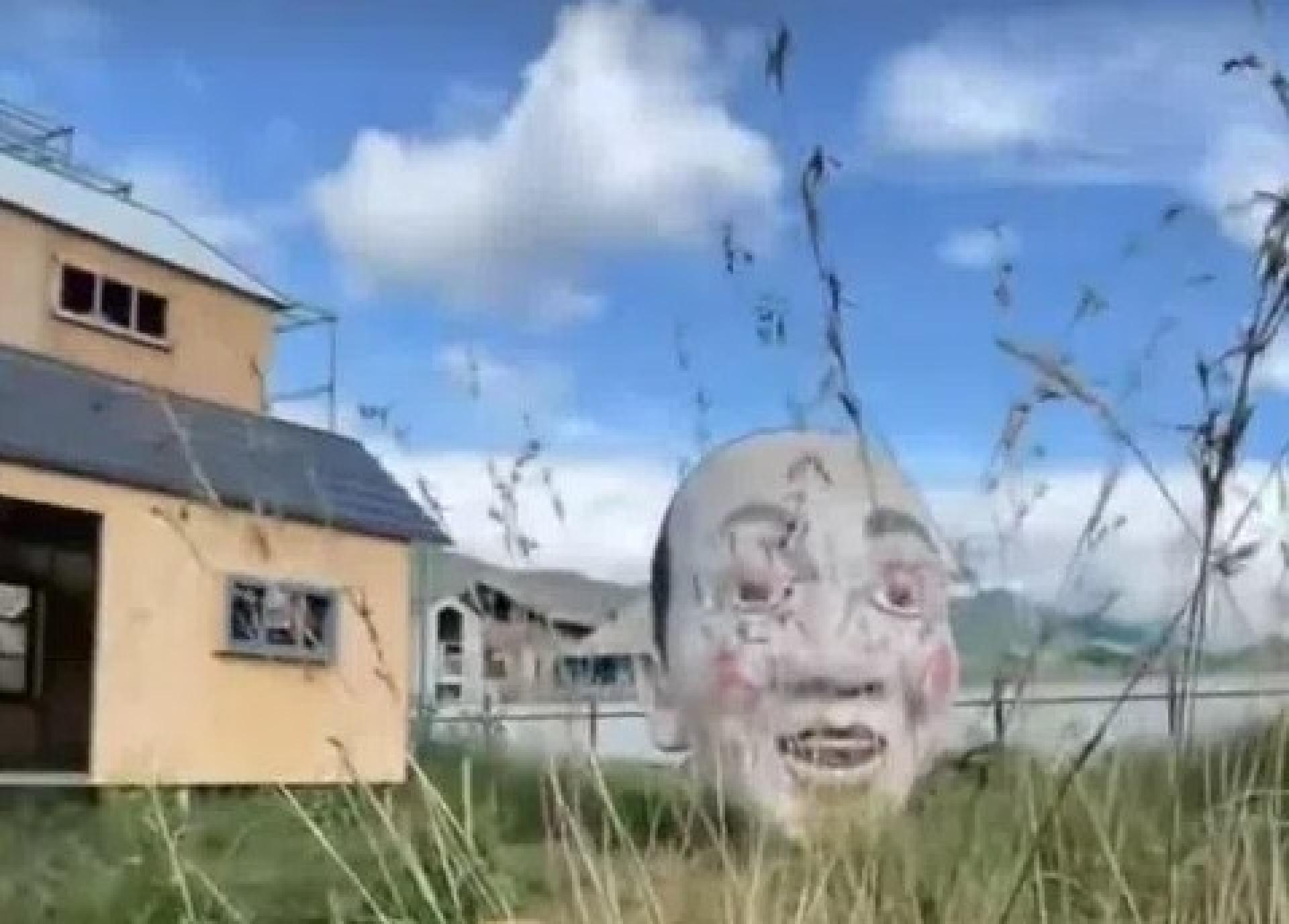 云南丽江荒野之国景区被指画风诡异，图为景区内的一个巨大人头作品。 （视频截取）