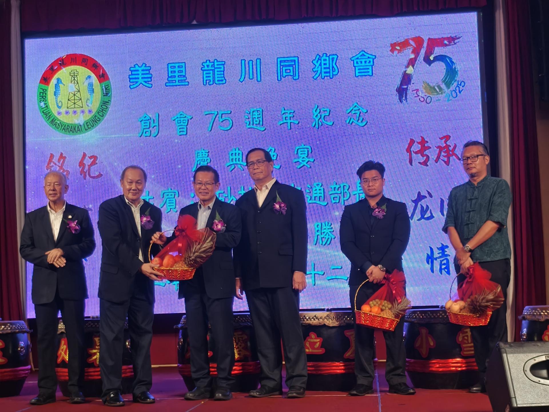 筹备会主席黄居恒（左2）在美里龙川同乡会主席杨日青（右3）陪同，赠送纪念品给主宾砂交通部长拿督斯里李景胜（左3）、嘉宾砂旅游部副部长拿督陈超耀（左）、美里市长俞小珊代表兼美里市议员余忠明（右）及美里区国会议员赵俊文助理邹梓建（右2）合影。