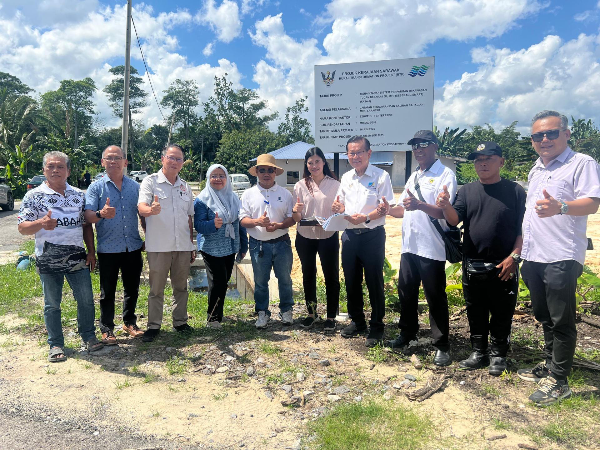 砂交通部长拿督斯里李景胜（右4）与社区领袖及承包商在杜当德沙拉斯第六期排水系统前合影。