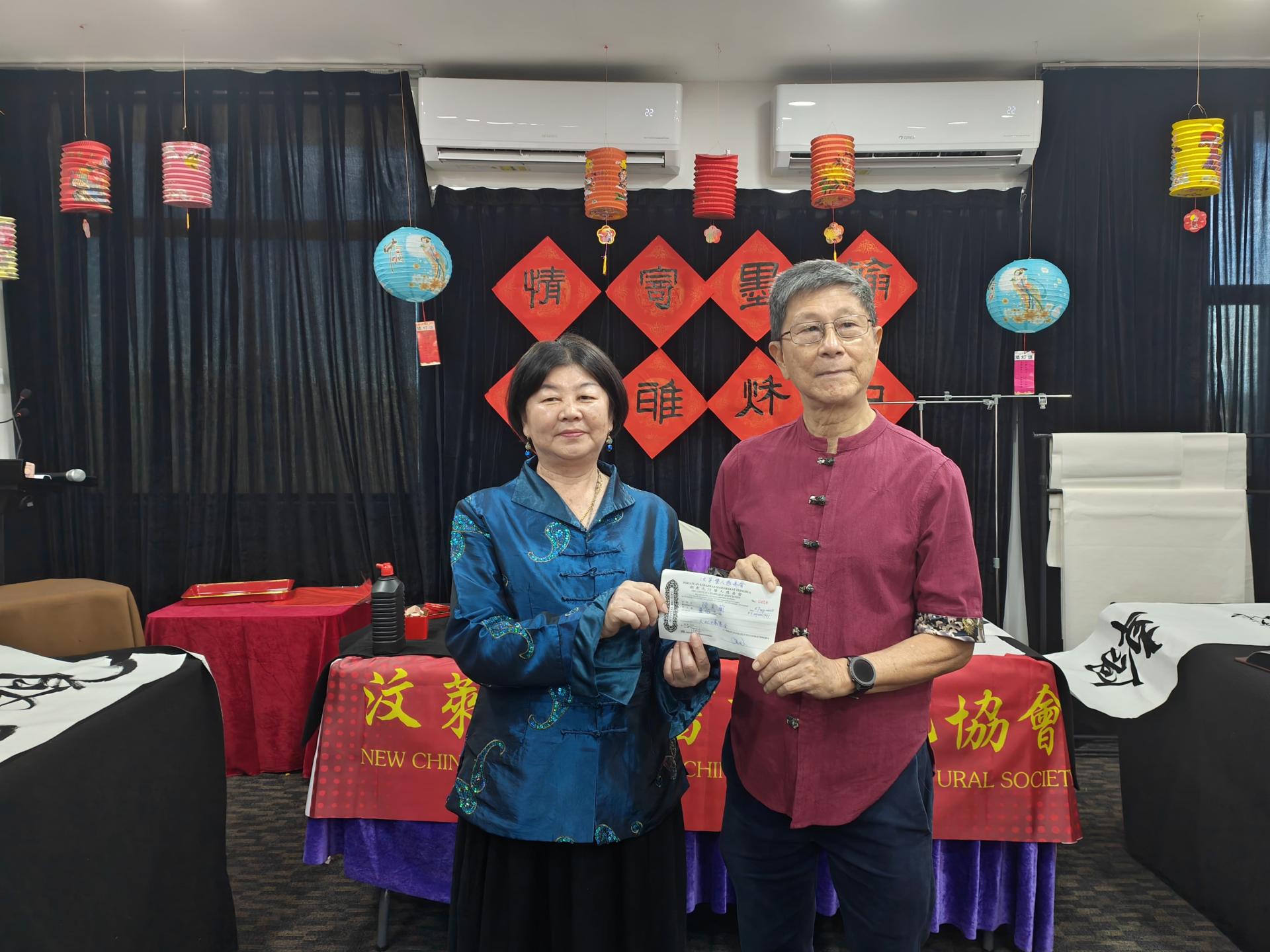 汶莱华人慈善会秘书长沈仁祥将众筹所得的收据交予陈美兰老师转发。