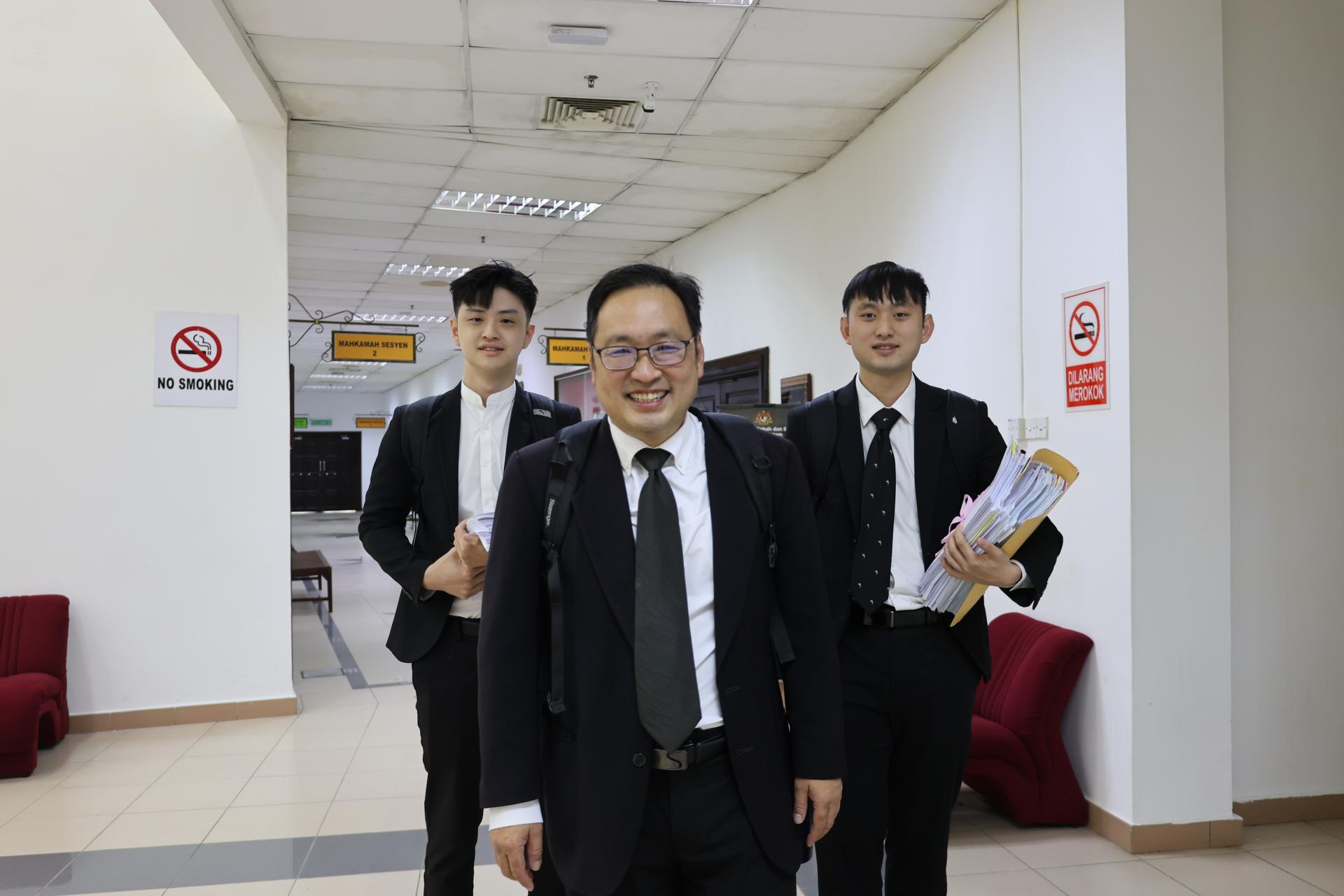 审讯结束后，张健仁（中）神情轻松地步出地庭。左及右分别是实习生刘家源及张翰贤。