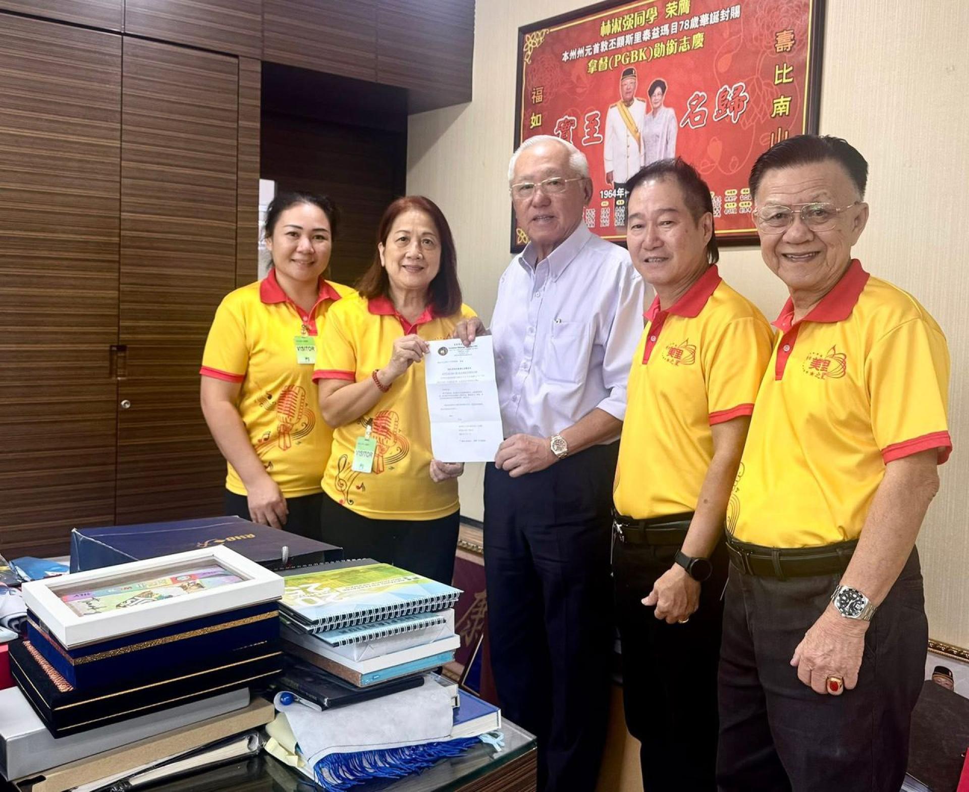 筹备会主席柯盈糸（左2）移交邀请信给永久名誉社长兼大会主宾拿督林淑强。左为秘书陈美珠，右起为公关主任萧云国，社长方孝胜。