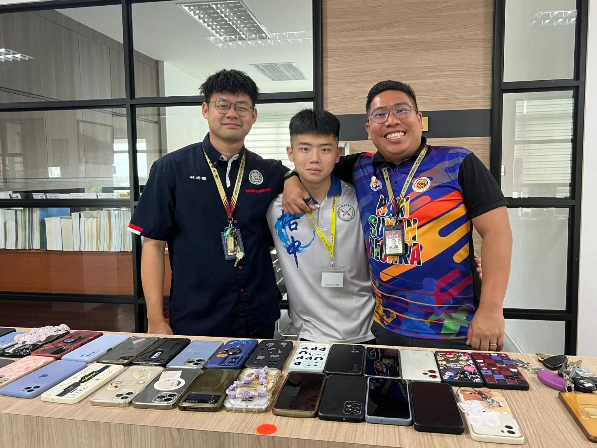 林成福（左）曾在母校培民中学担任信息与通信技术（ICT）教师，与老师及学生合影留念。