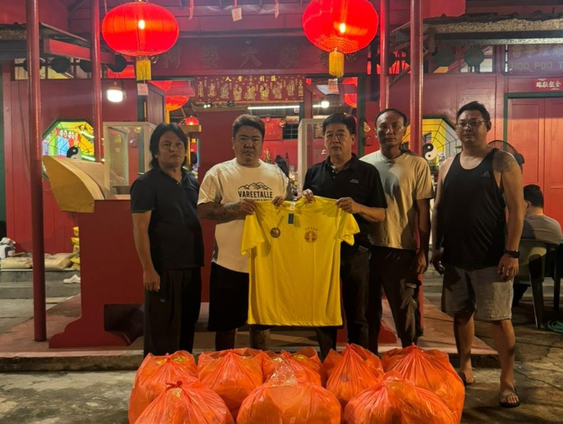 本庙主席温天鸿与出游队伍负责人吴福中移交出游制服忠福宫主席许义华以及神事组员。