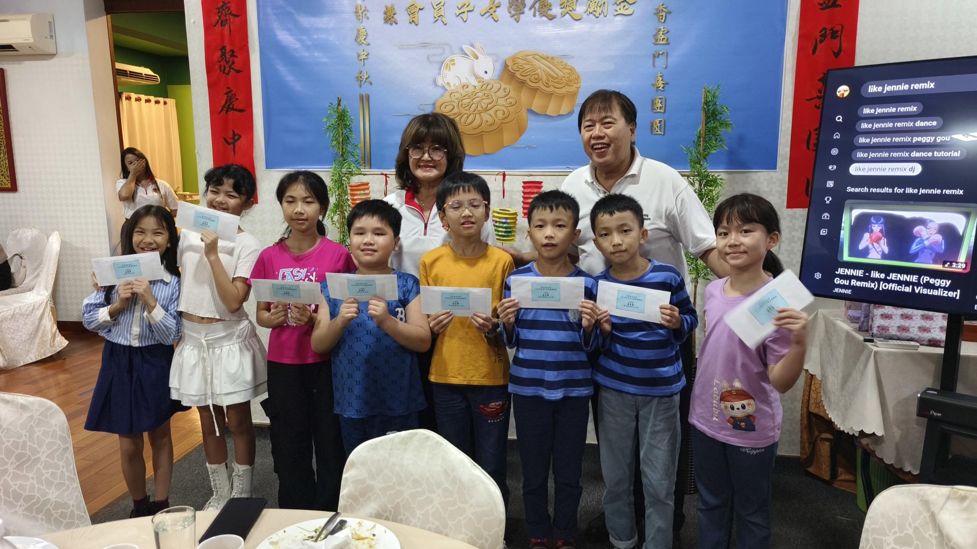 会长甲必丹余继香（后左）颁发小学组学优奖励金后与得奖者合影。
