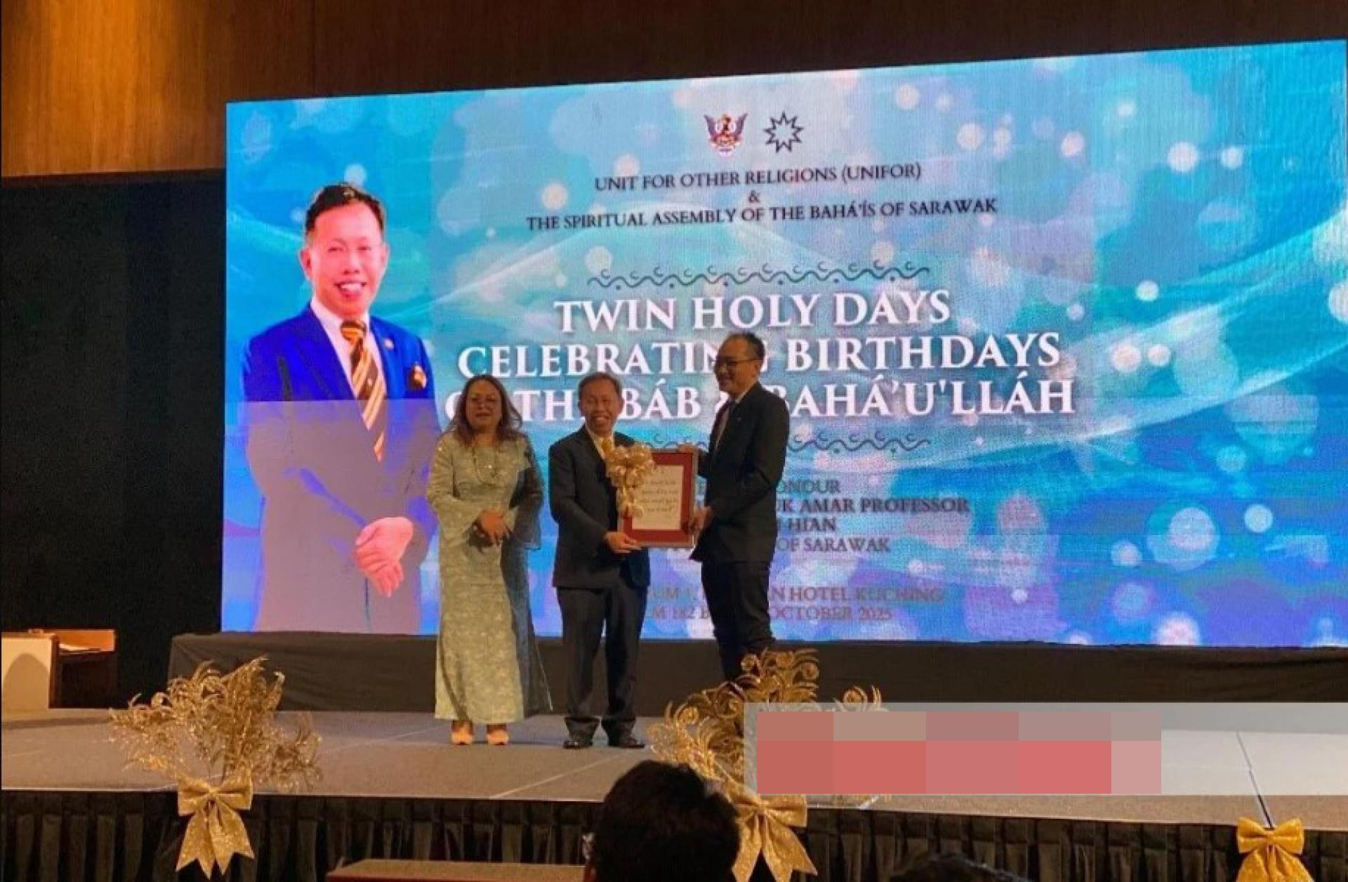 沈桂贤（中）在乔治娜见证下，接受砂拉越巴哈伊精神议会代表Dr Shehab Phung Chee Wei赠送的感谢纪念品。