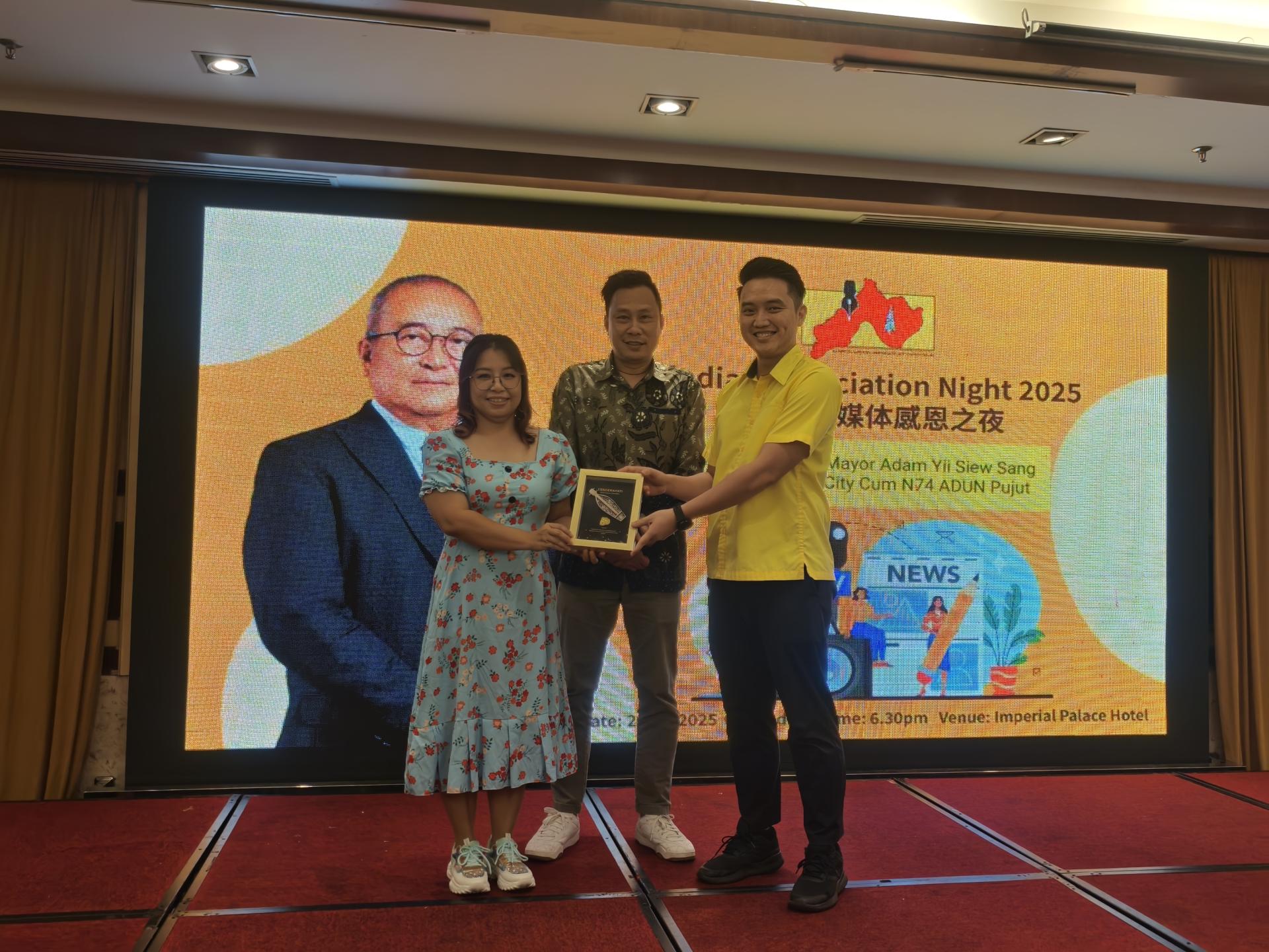 筹备会主席范文琦（左）在会长蔡传晋陪同，赠送纪念品予美里市长俞小珊，由其代表砂人联党埔奕支部青年团团长许勋扬（右）接领。