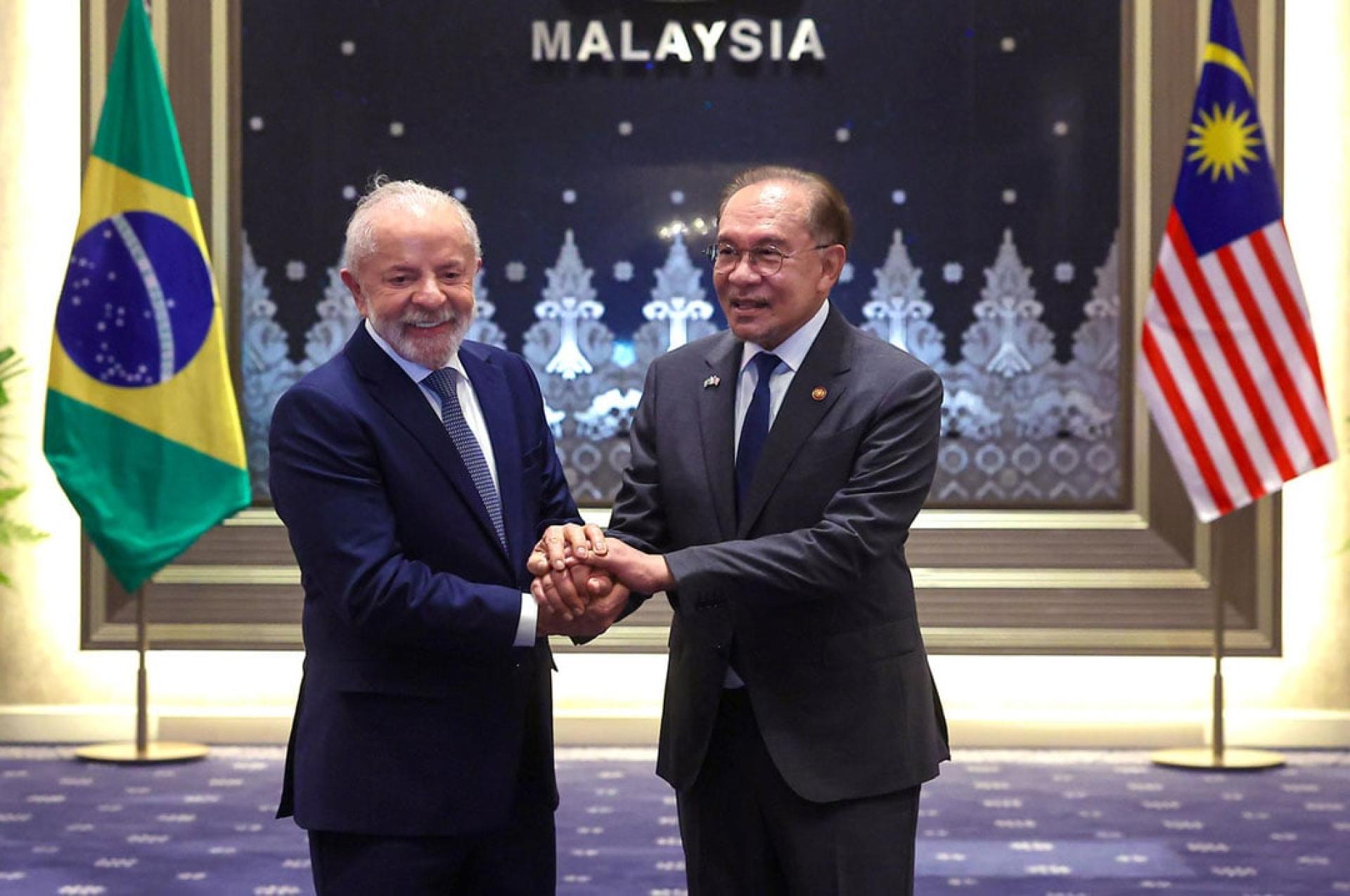 安华(右起)与卢拉紧握彼此双手,宣告两国将致力加强在半导体、食品科技、教育与文化领域的合作。