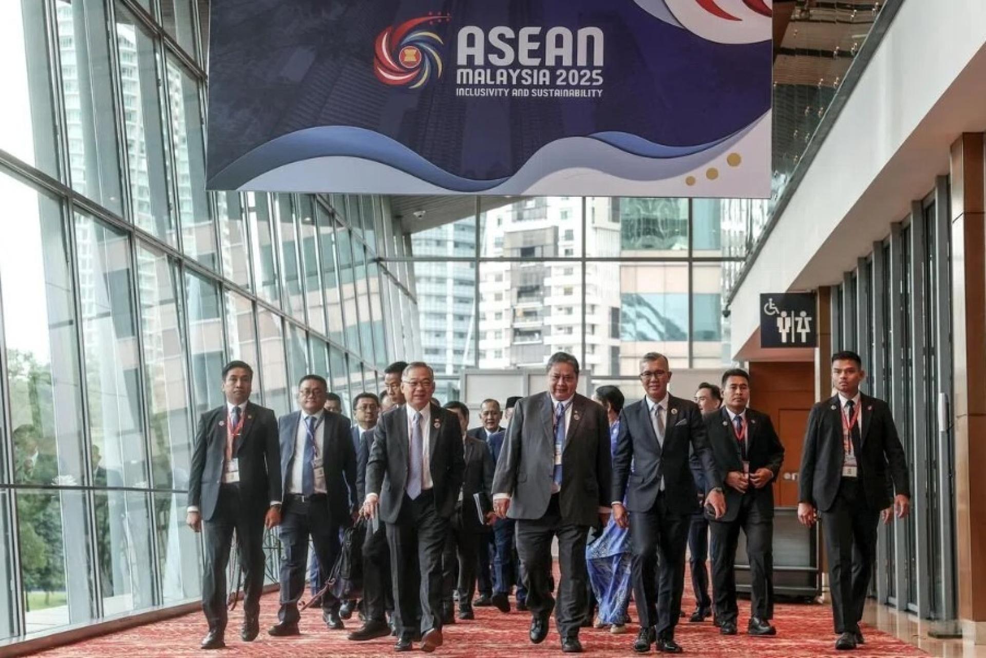 第26届亚细安经济共同体理事会会议及亚细安数码经济框架协定特别会议星期五在吉隆坡会展中心举行。新加坡副总理兼贸工部长颜金勇(前排左)、印度尼西亚经济事务统筹部长艾尔朗加(前排中)及马来西亚投资、贸易及工业部长扎夫鲁(前排右)一同步入会场。