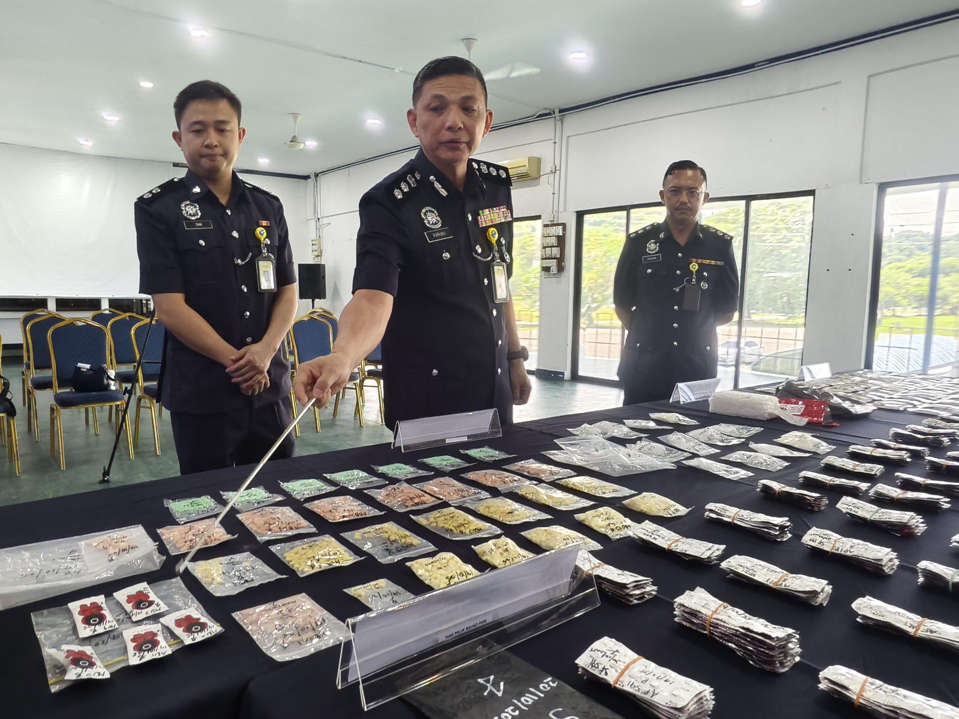 美里警区主任李炳强助理总监（左2）向媒体展示起获的各类毒品。