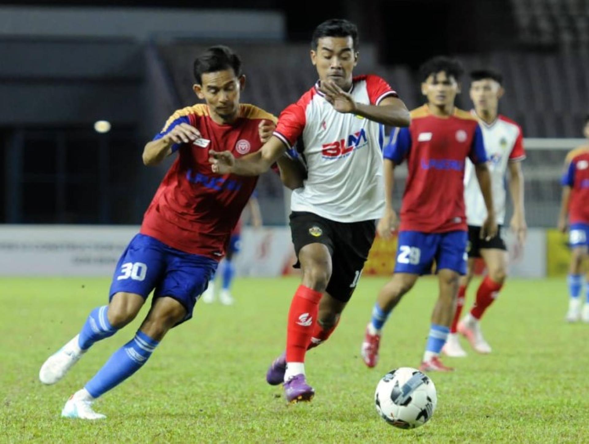 诺曼（左）阻截试图带球突破的穆罕默沙菲特里沙林（Mohammad Shafitri Salim）。