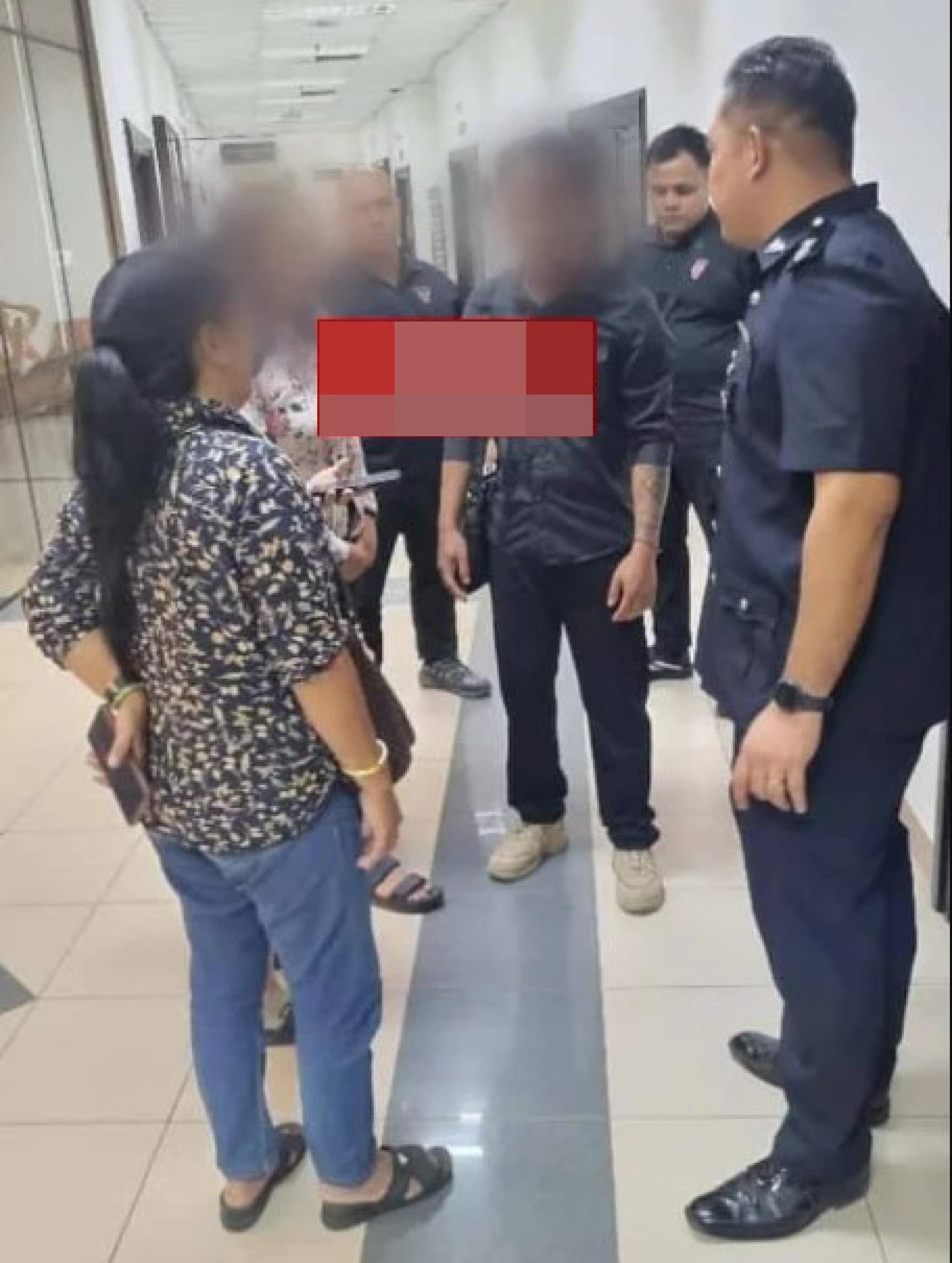 首名被告（黑衣者）与妻子（左）在法庭外与警方官员交谈。