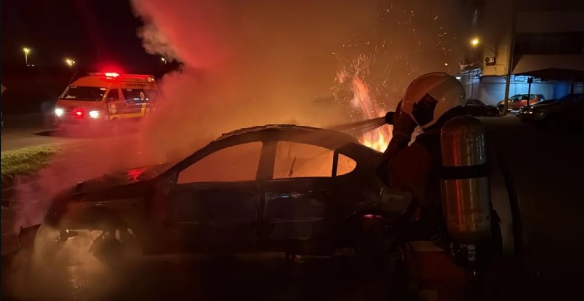 消防员奋力扑灭燃烧中的汽车，地点位于富贵莫哈末中学校外。