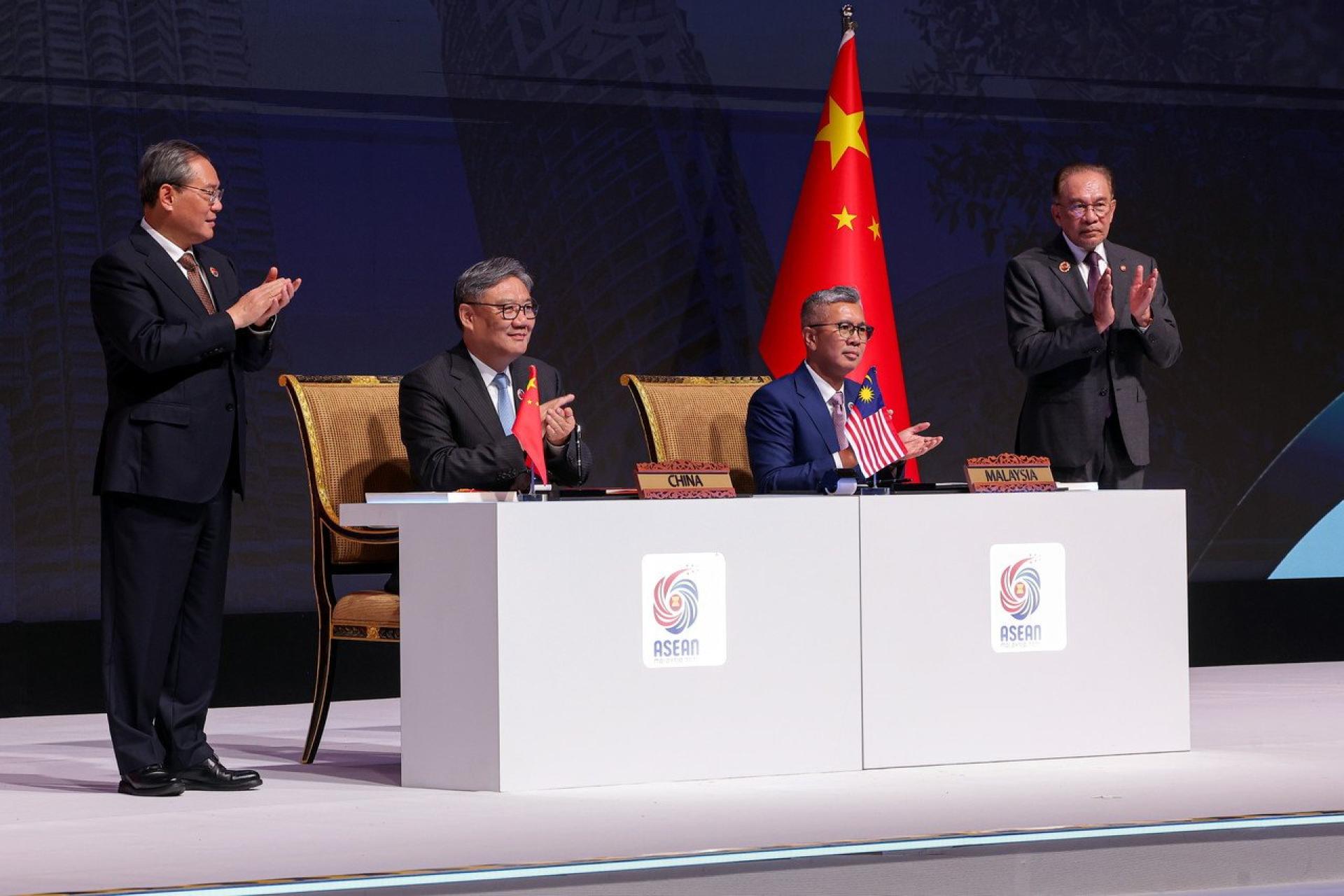 东姑扎夫鲁（右2起）和王文涛签署《东盟—中国自由贸易协定3.0》，由安华（右）和李强（左）在场见证。