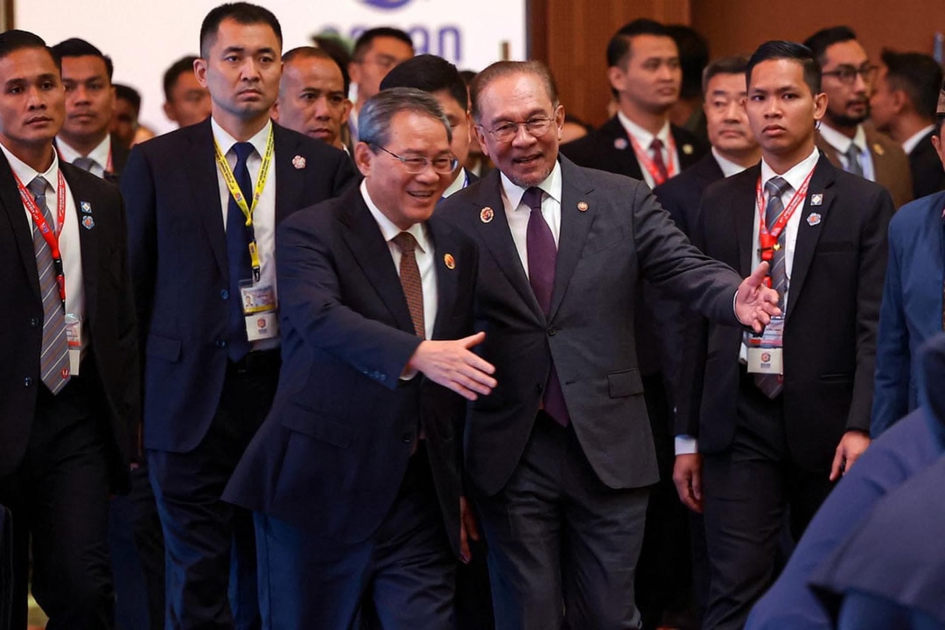 安华(右起)领着李强进入会场,并向他介绍与会者。