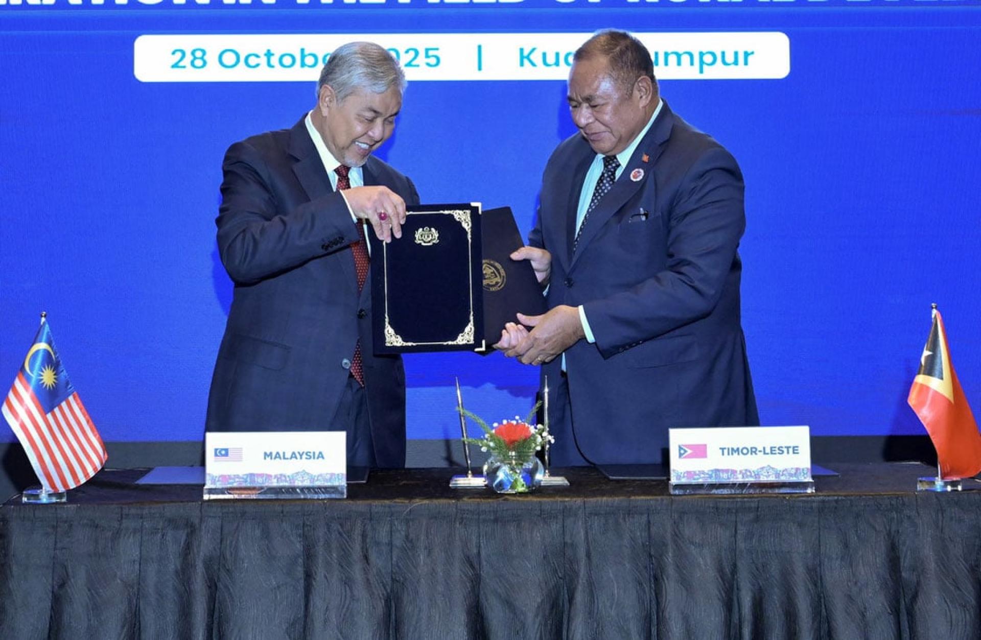 阿末扎希（左起）与弗雷塔斯，签署及交换有关两国在乡区发展加强合作的谅解备忘录。