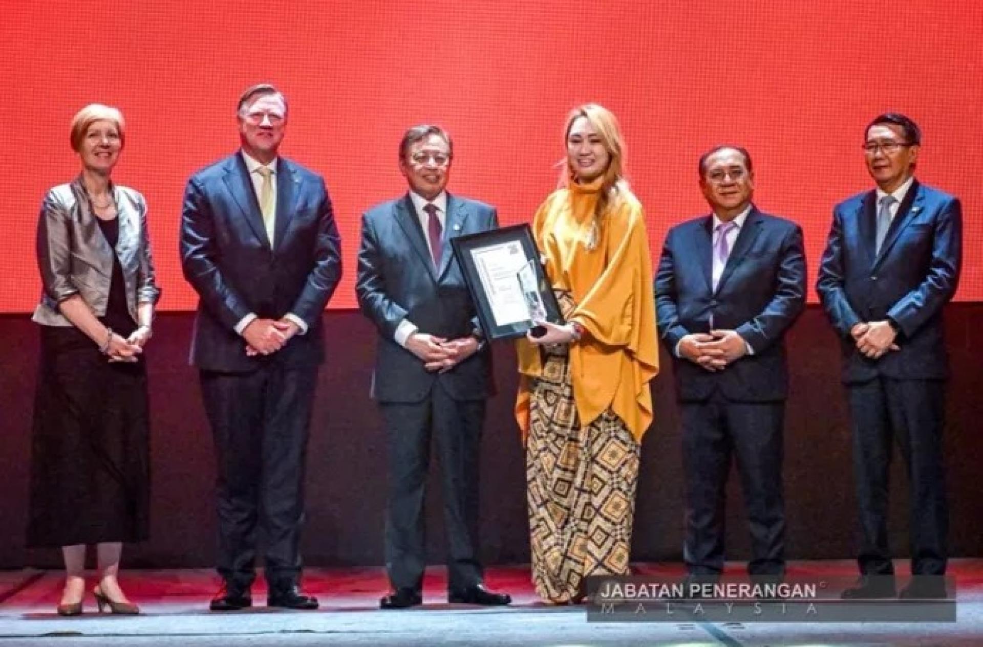 阿邦佐哈里（左3）在2025年10月28日举行的斯威本科技大学砂拉越校区25周年庆典晚宴上，将“杰出校友奖”颁发予Chan Tyng Tyng（右3），现场贵宾共同见证这一时刻。