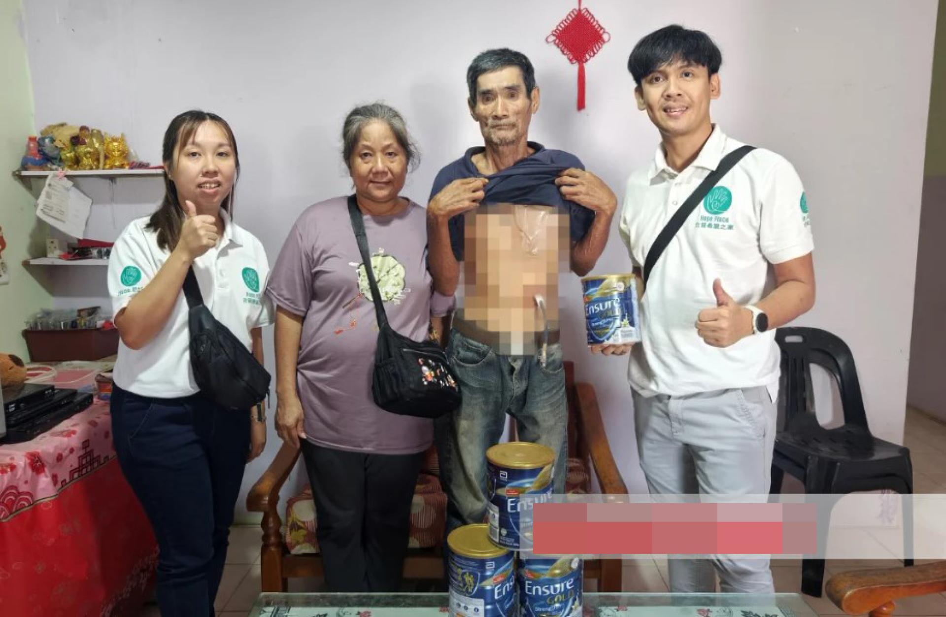 希望之家成员Mary Vun（左）与Griffin Deng（右）日前前往古晋德沙维拉花园探访Phang Jee Fatt（站者左3）及其妻子，并移交特殊奶粉援助品。