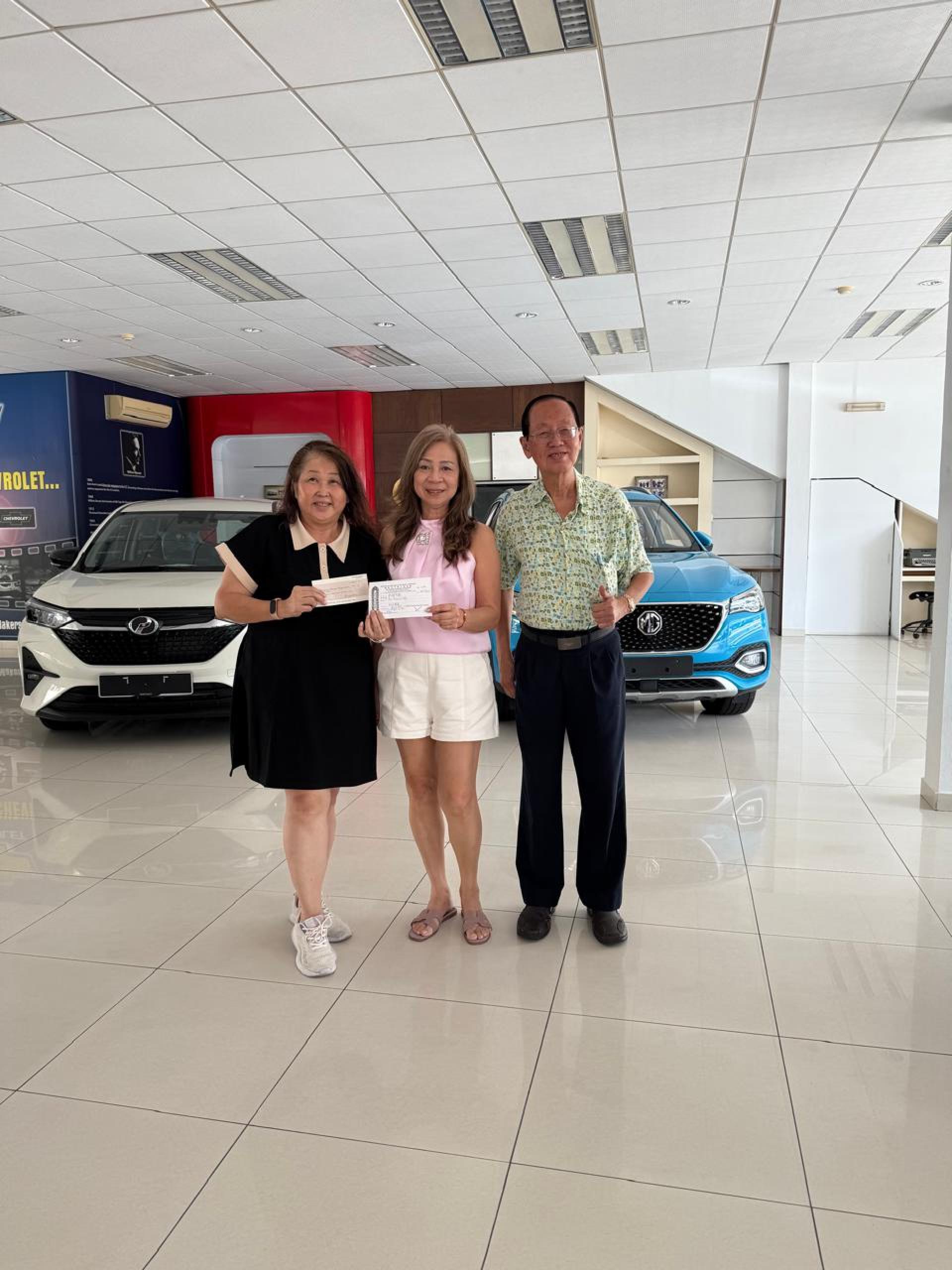 马来弈梁永宁夫人杨玉兰(中)移交捐款予沈秋香,