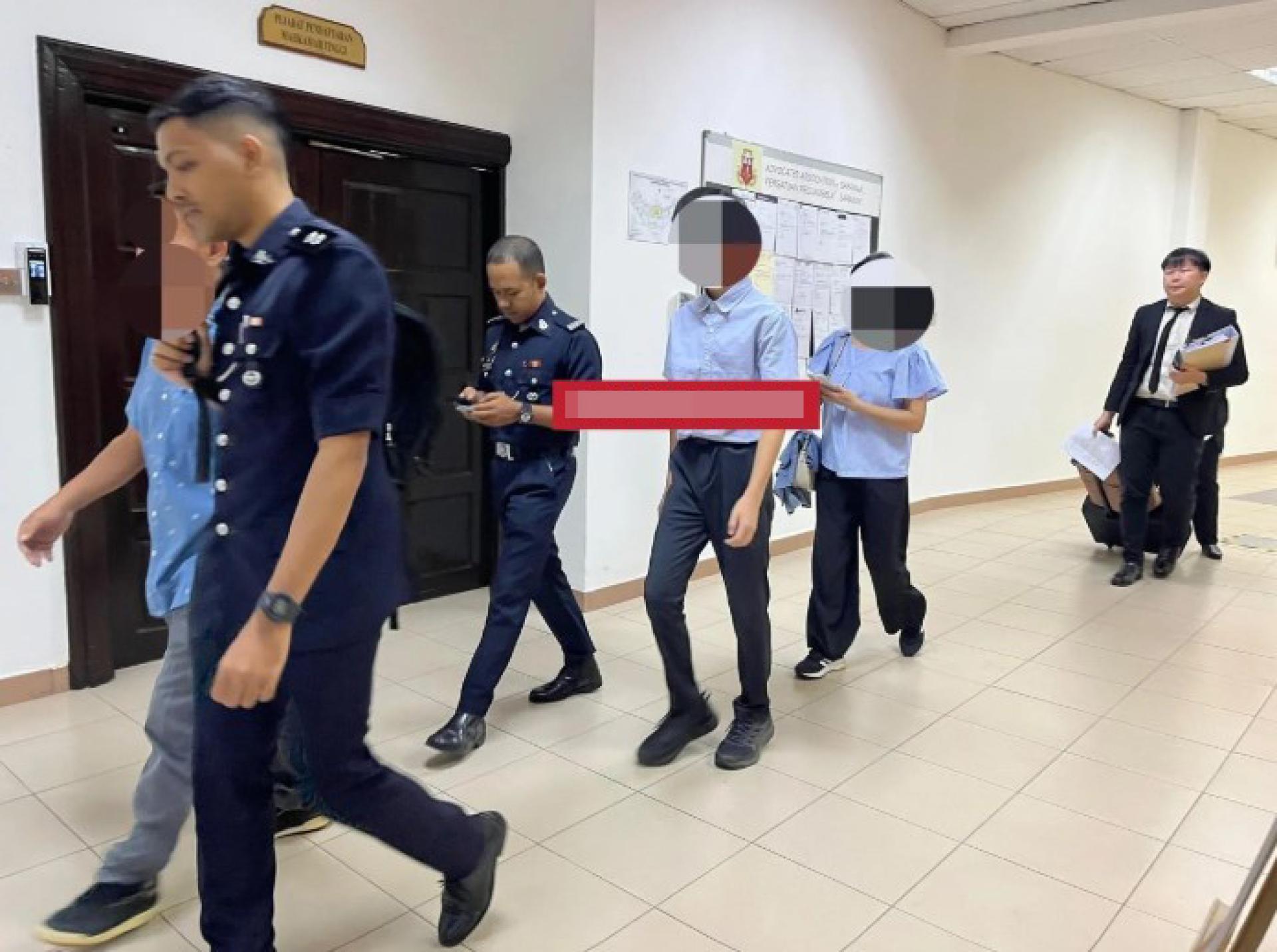 第一名被告（浅蓝色衣服者，中后方）在其父母陪同下，由调查官莫哈末哈菲津哈伦警长陪伴离开第二推事庭房间。