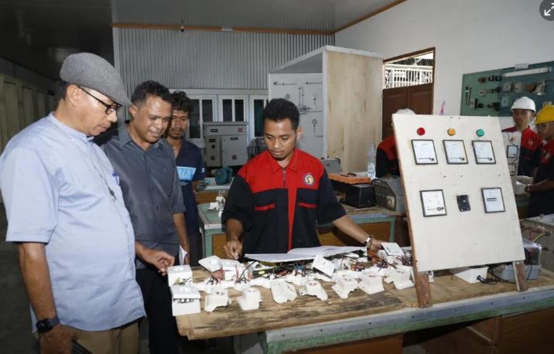 东帝汶唐博斯科职能学院院长热苏斯(左一)与东帝汶教育部职能院校行政管理部门主任希梅内斯(左二)走访课室,了解学生组装电板的学习进度。