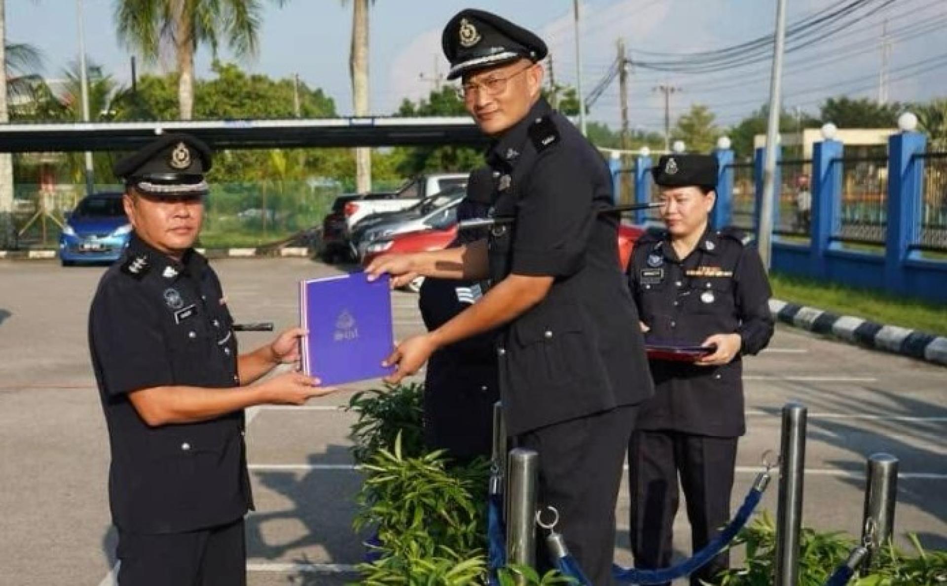 副警监慕哈末里扎阿里亚斯在10月份沐胶警区月度集会上，向一名警员颁发嘉奖证书。