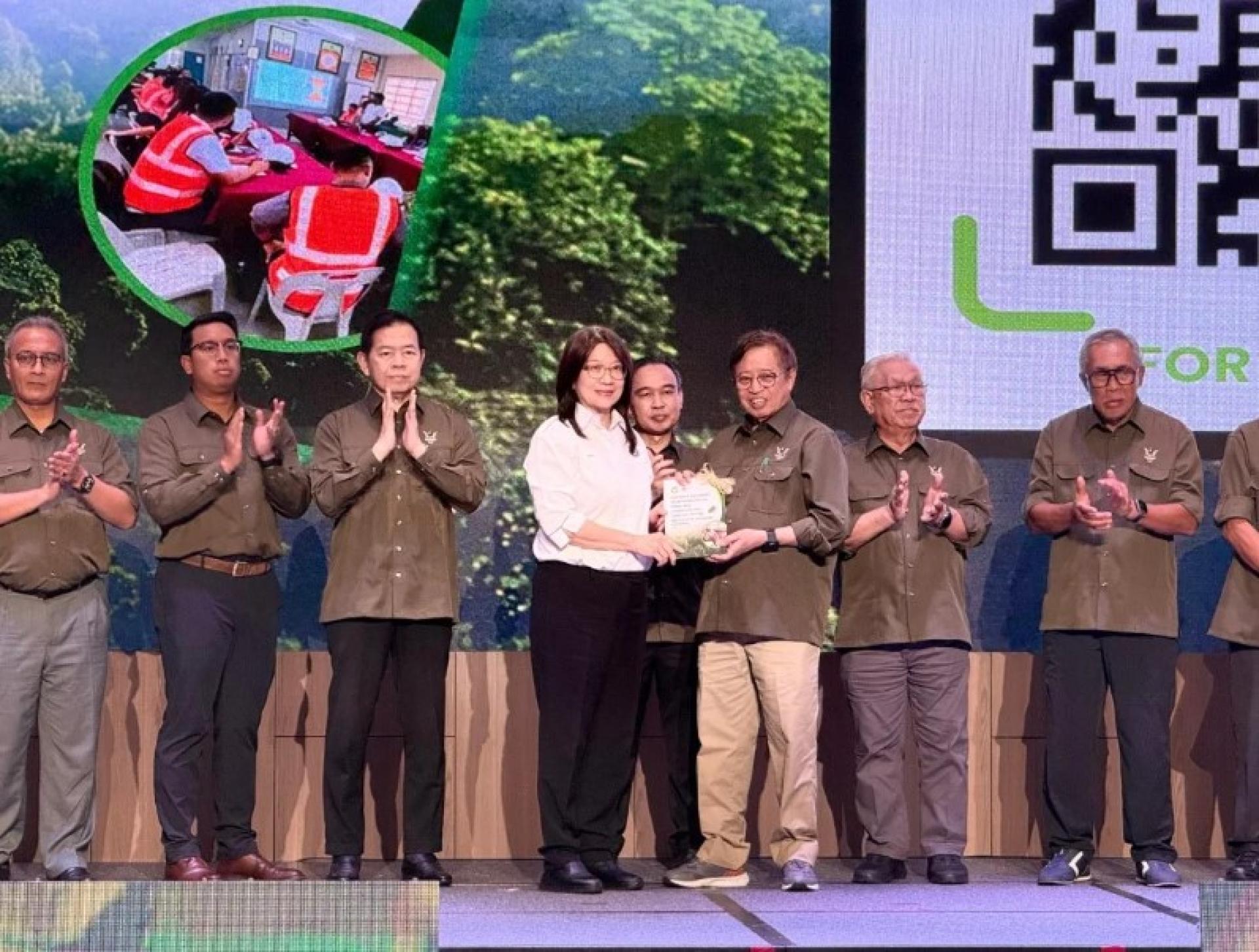 阿邦佐哈里（右3）从砂拉越木材公会首席执行员Annie Ting手中接过指南文件。