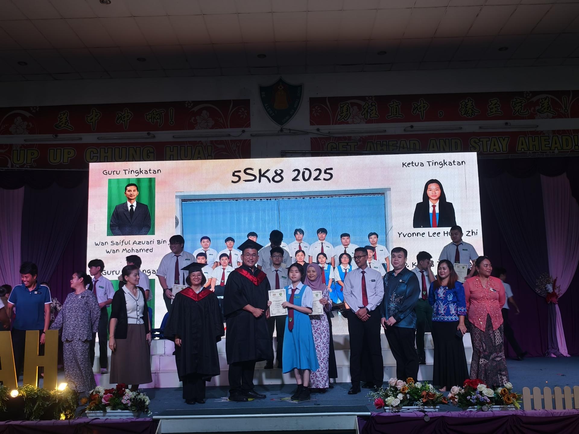 美中校友会副会长陈政锖在校长赖佳玲（左者）及班导师陪同，颁发毕业证书给5SK8班学生。