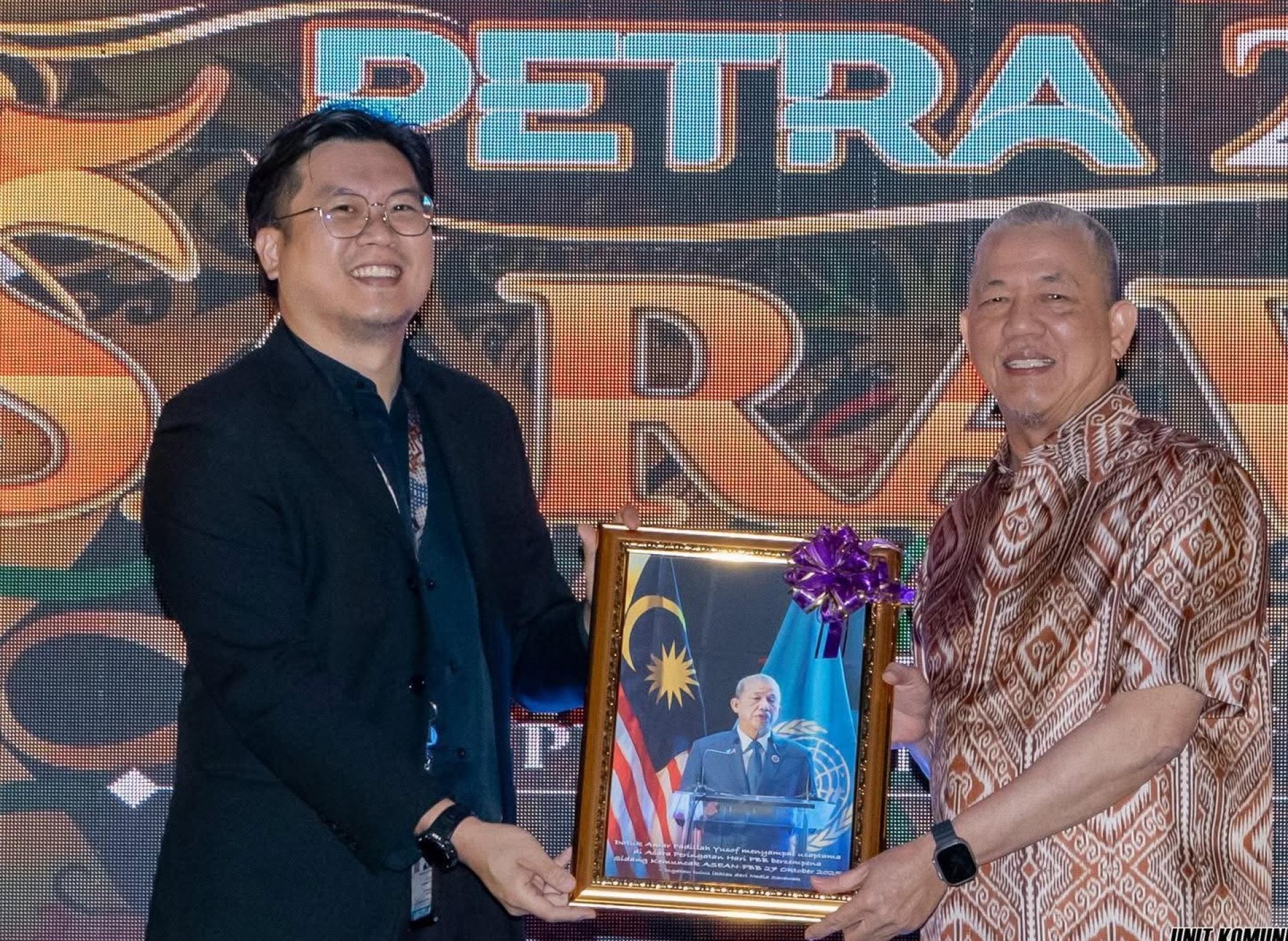 古晋省新闻从业员协会主席张德伟赠送纪念品给副首相拿督阿玛法迪拉尤索。