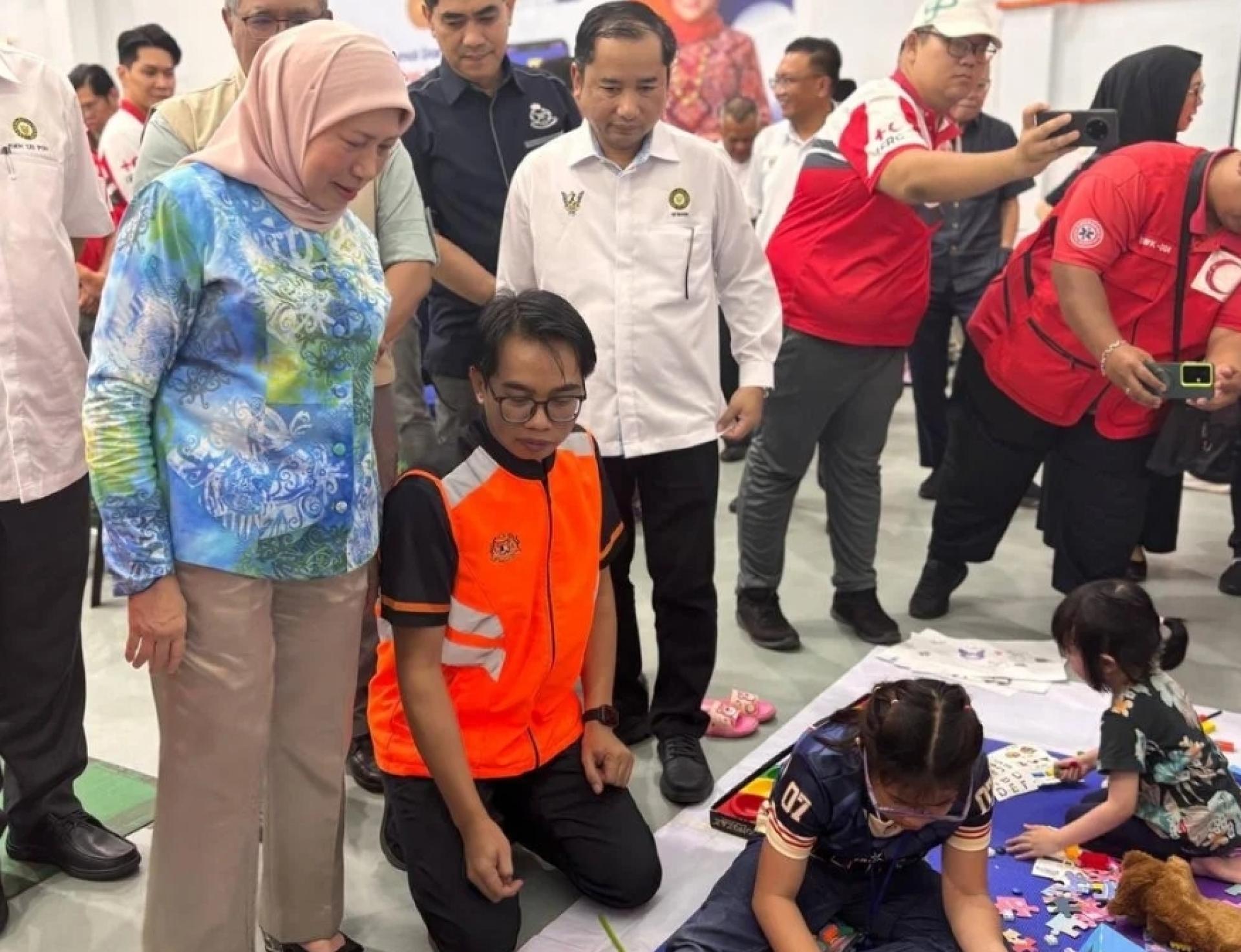 拿督斯里南茜（左）向工作人员了解中心内的操作。