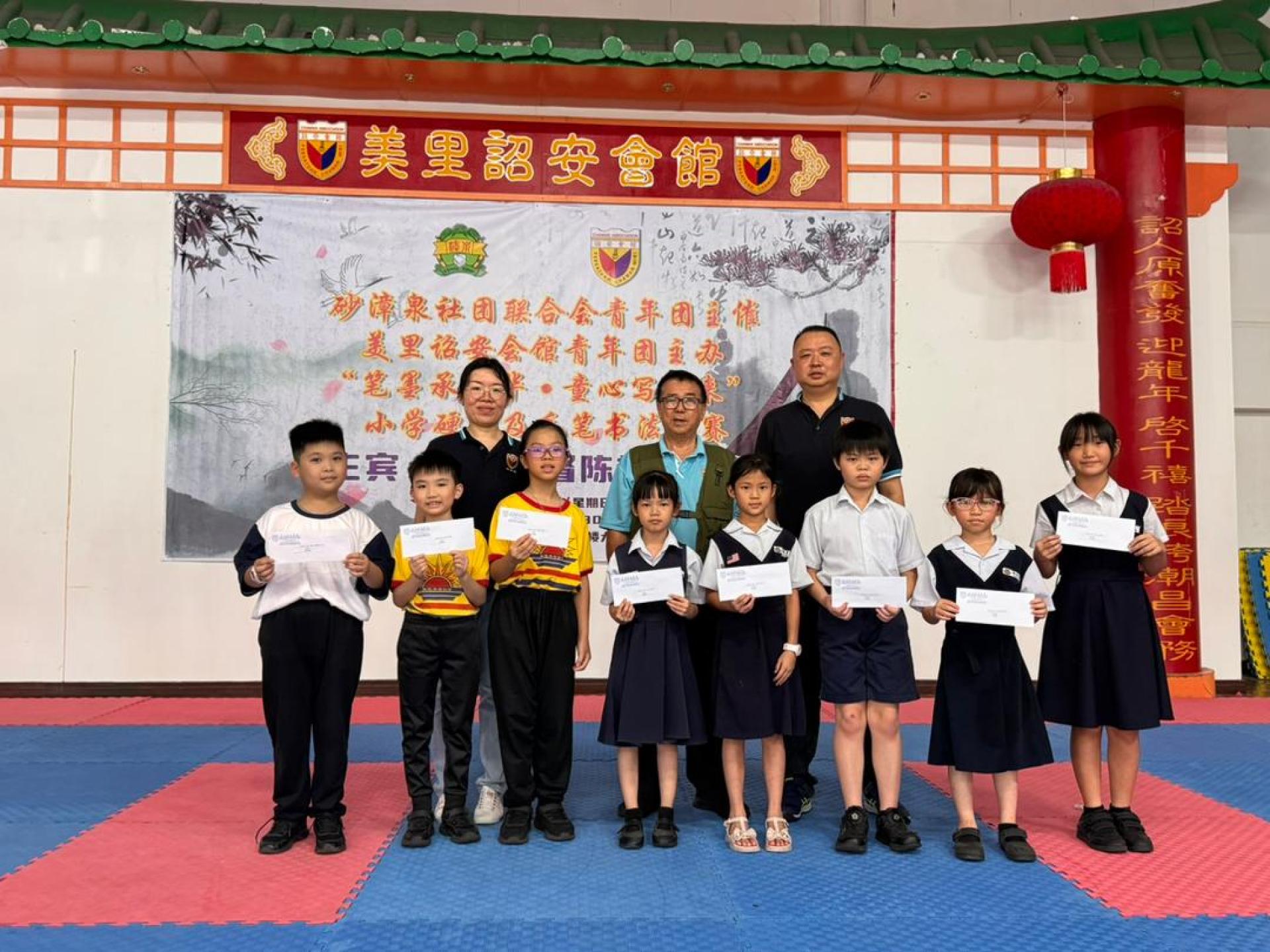 小学低年硬笔组全体得奖者合影。 后排左起为筹备会主席沈佳欣，甲必丹沈炎龙及青年团团长许伟强。