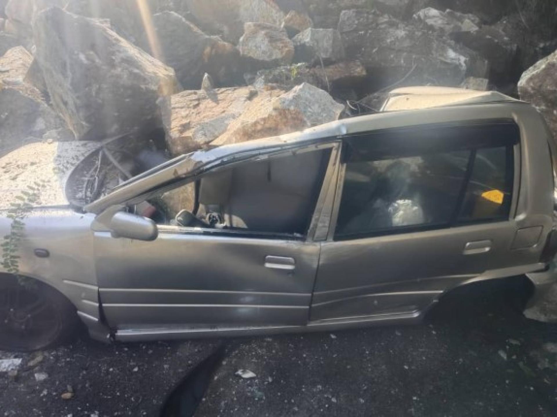 多辆车子遭崩落的巨石砸中受损。