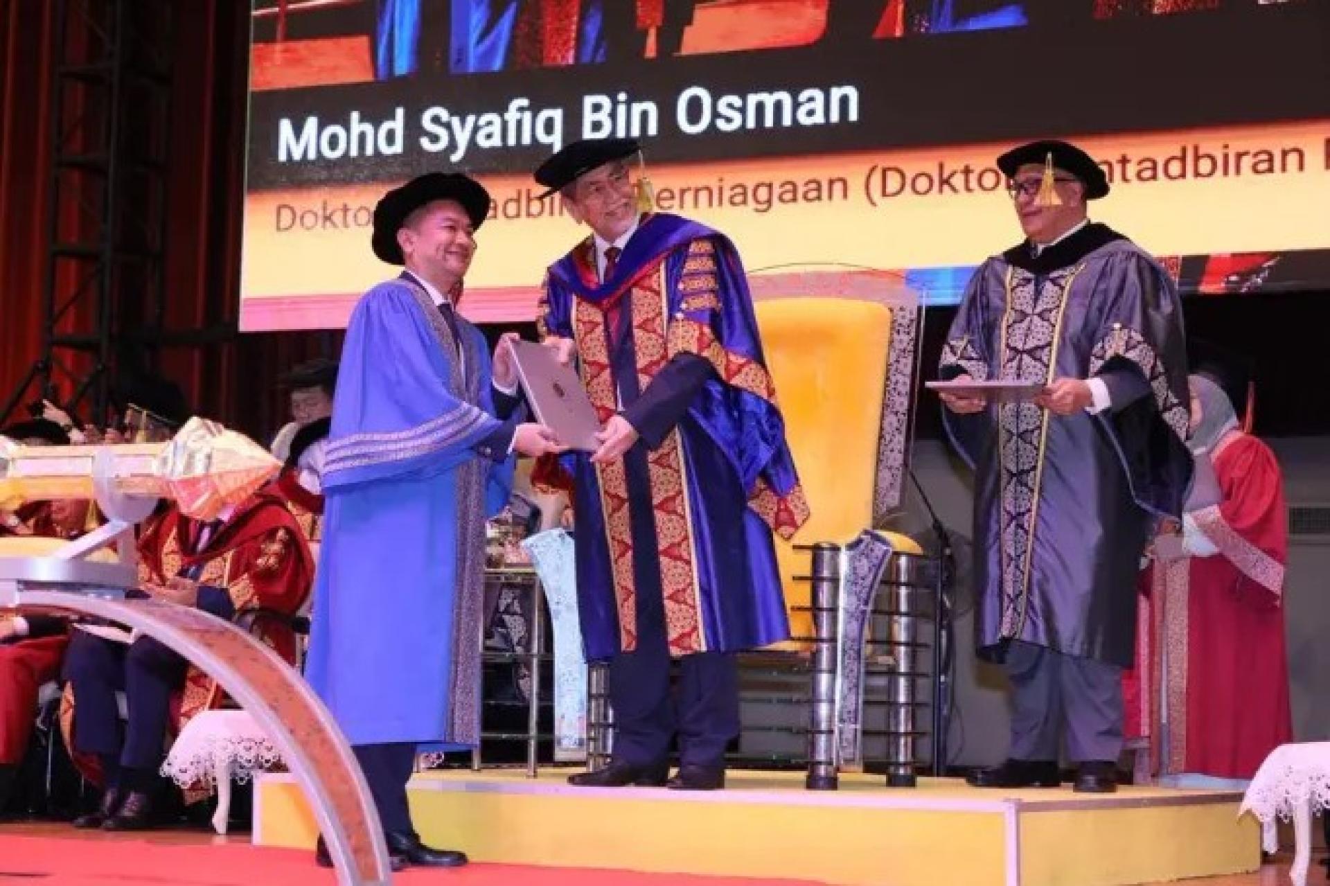 旺朱乃迪（中）在2025年11月3日的砂大毕业典礼上为毕业生颁发毕业证书。