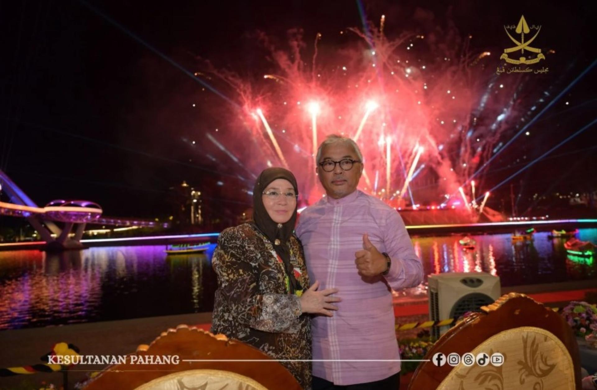 彭亨苏丹阿都拉陛下与苏丹后东姑阿芝莎伉俪，于古晋河滨砂拉越鼓节夜空烟火下合影留念。