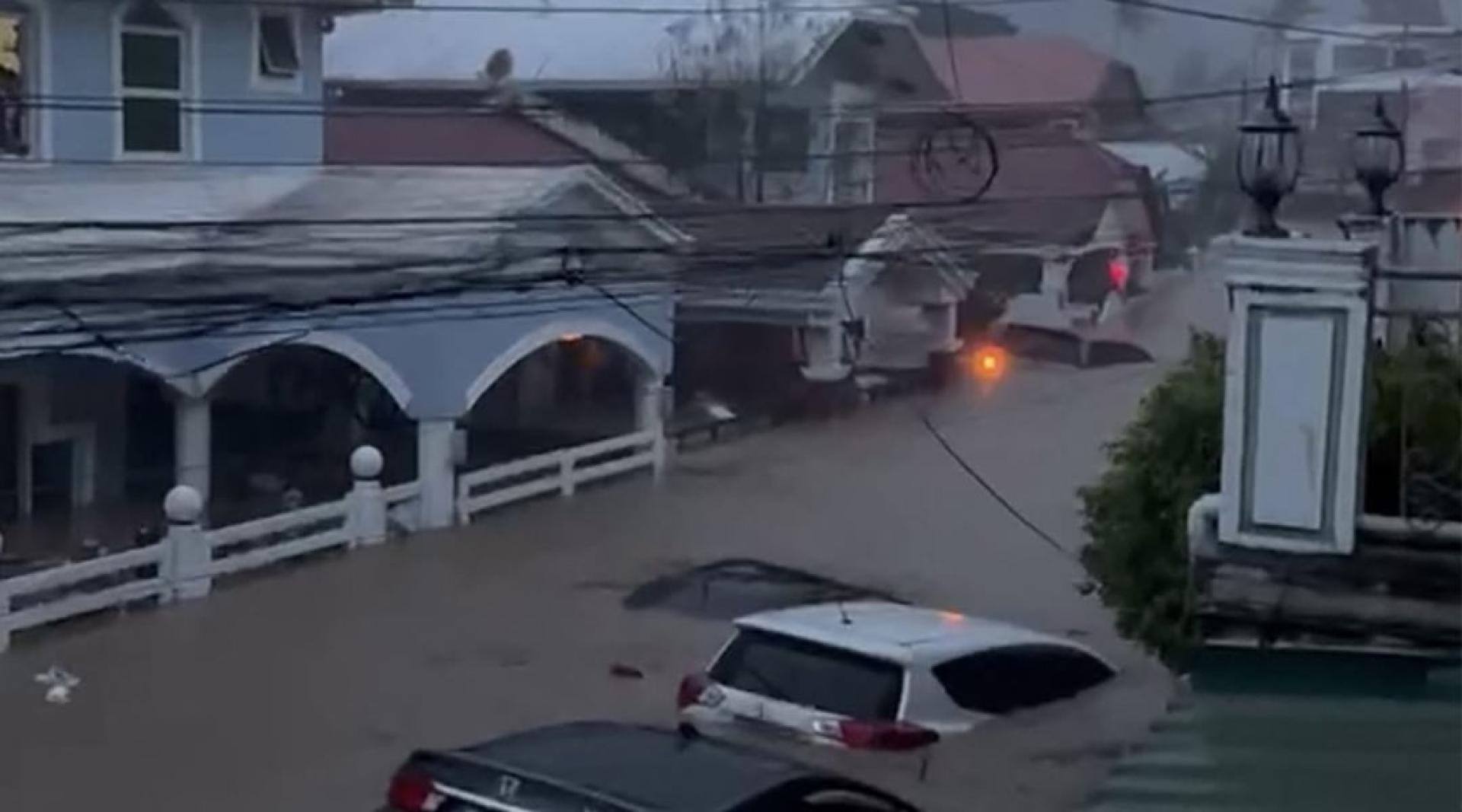 在宿雾市，汽车在被洪水淹没的街道上漂流。