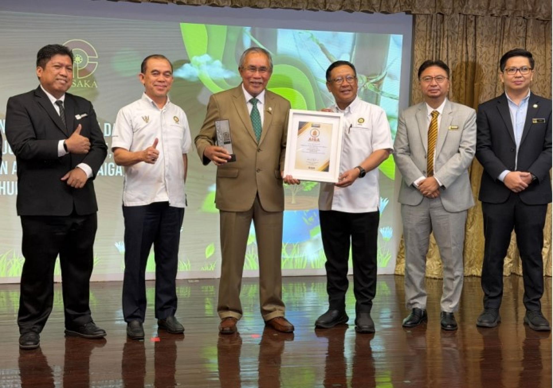 连达立（左3）手持AIGA金奖。右3为再纳，右2为砂森林局局长拿督哈姆丹莫哈末（Datu Hamden Mohammad）等人。