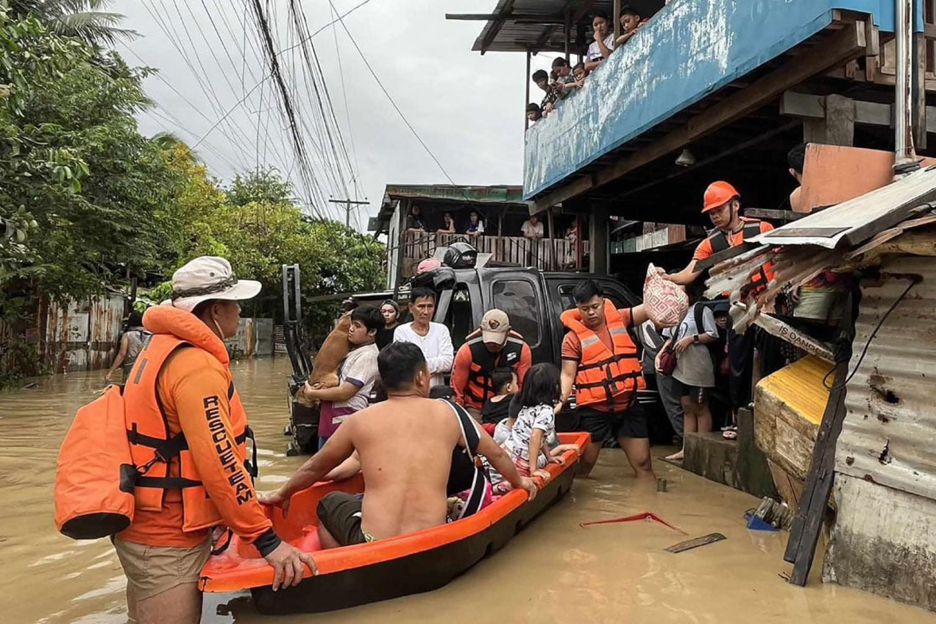 在台风“海鸥”带来的暴雨过后，菲律宾海岸警卫队人员正在疏散被洪水淹没的居民。