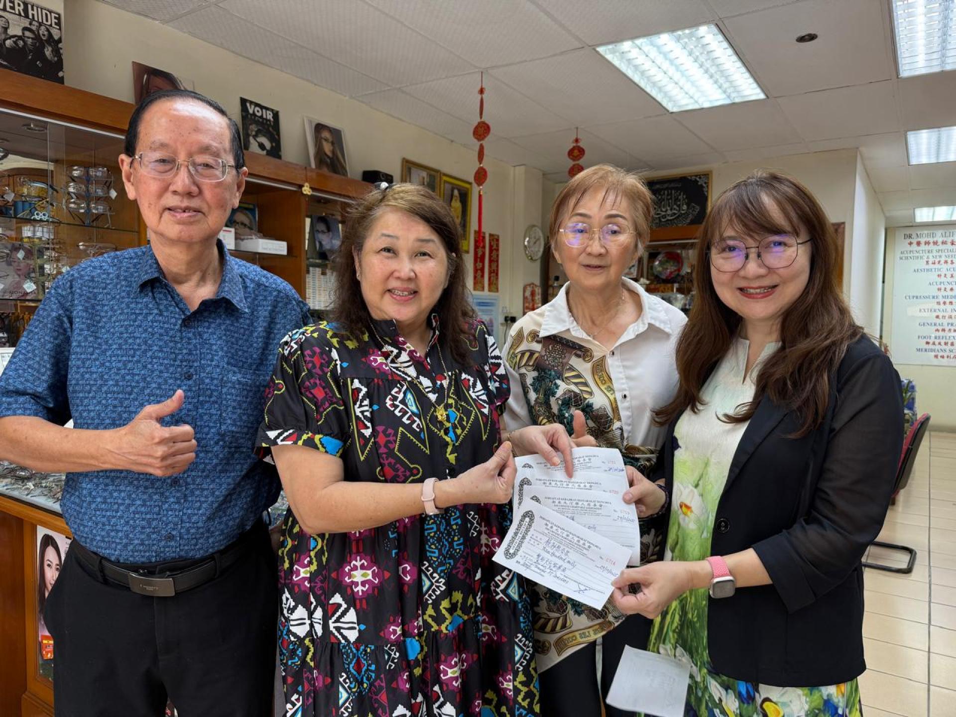 饶美云（右2）、饶秘僐（右）姐妹移交善款予沈秋香理事。