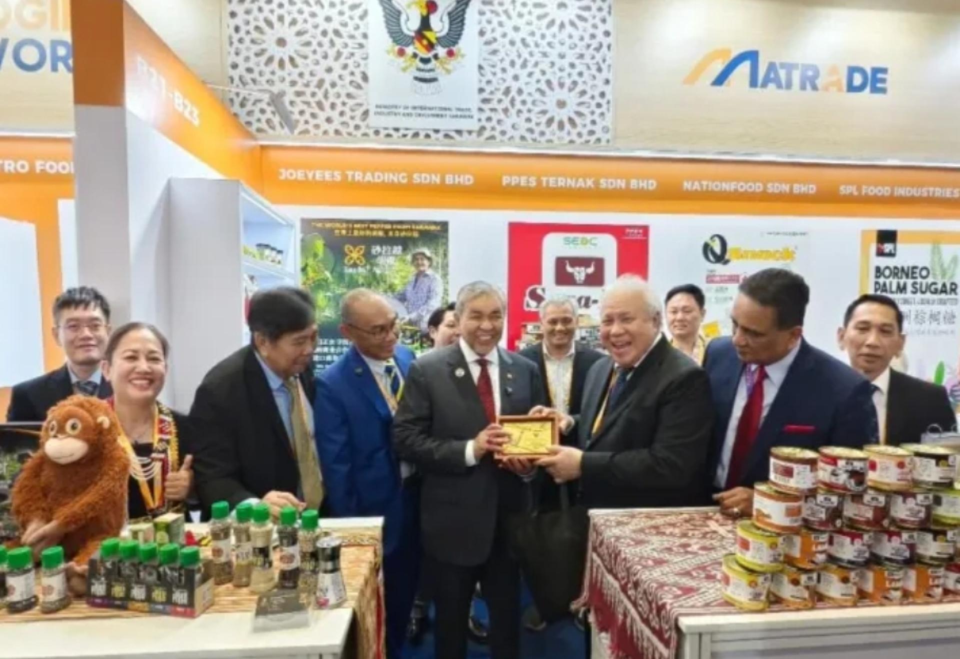 副首相拿督斯里阿末扎希（左）赠送纪念品给砂拉越参展摊位，并由砂副总理拿督阿玛阿旺登雅（右）接收。